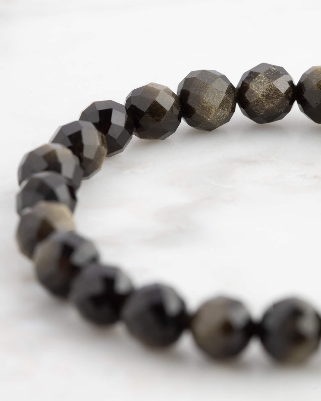Pulsera de Obsidiana Dorada facetada vista en ángulo, cuentas negras con brillo dorado