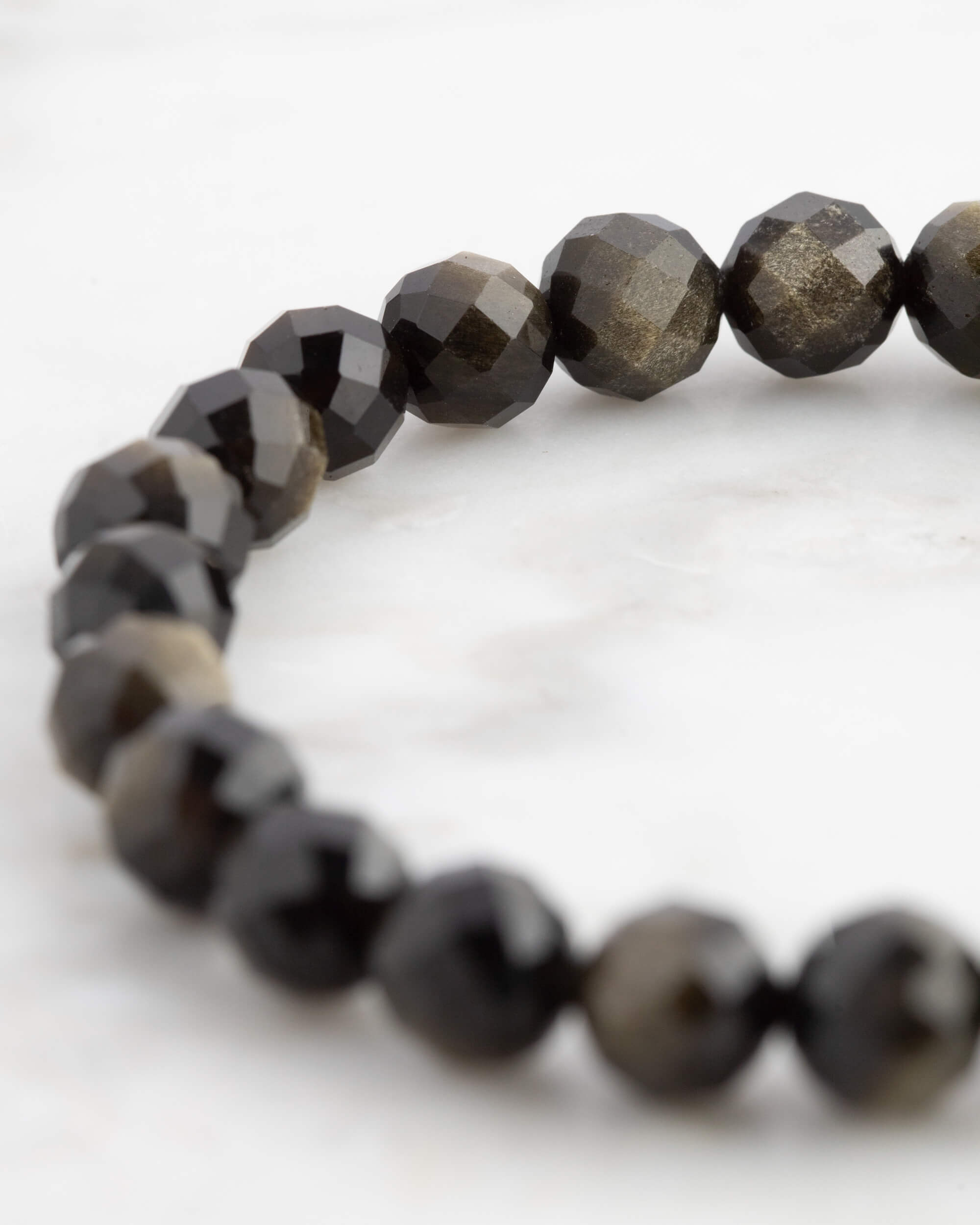 Pulsera de Obsidiana Dorada facetada vista en ángulo, cuentas negras con brillo dorado