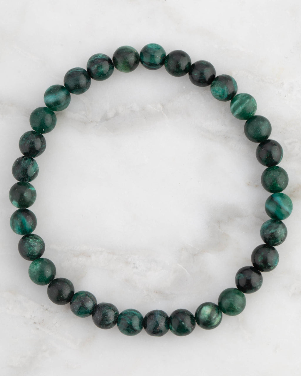 Pulsera de Esmeralda en Matriz de Biotita, pieza completa en círculo sobre mármol claro