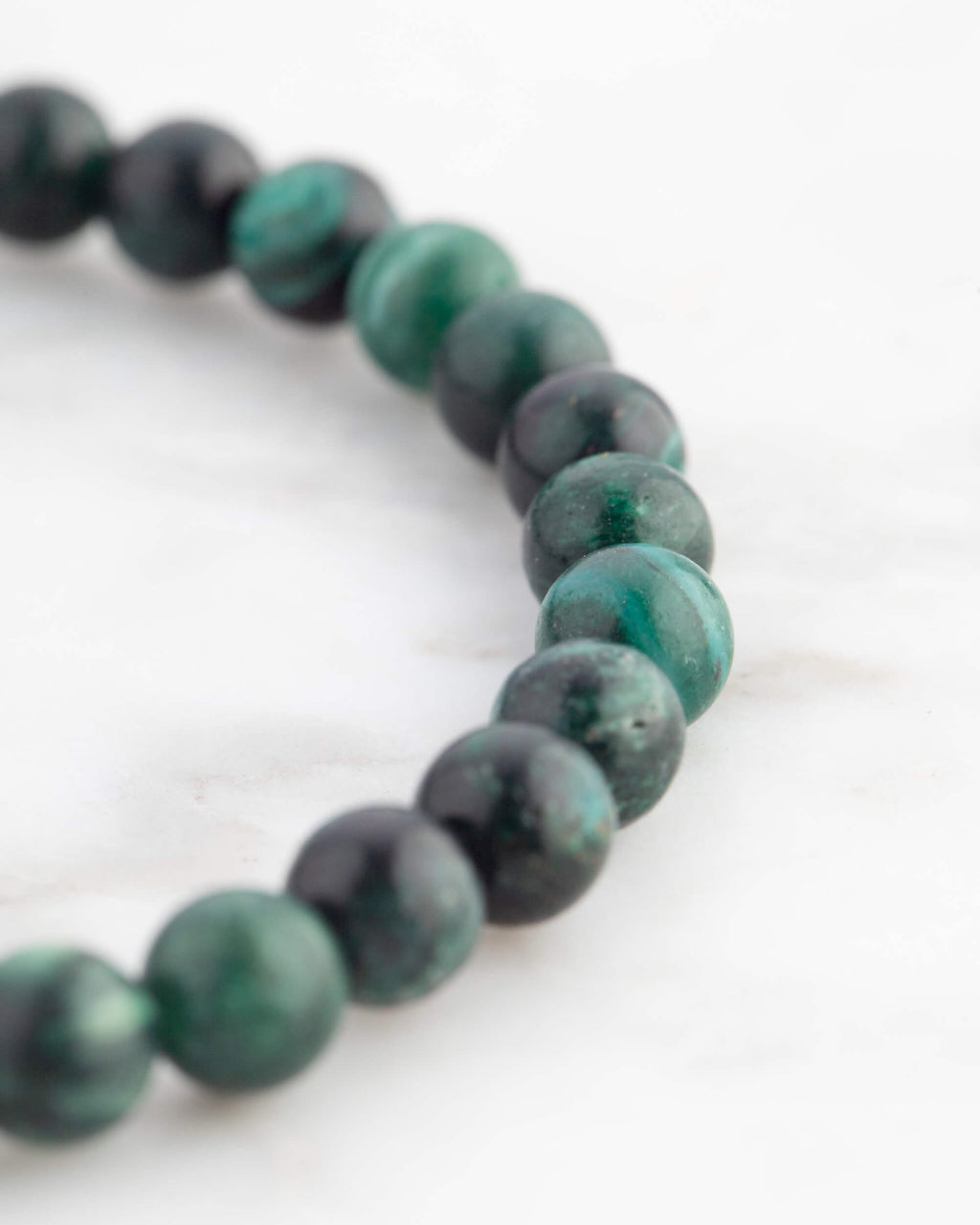 Pulsera de Esmeralda en Matriz de Biotita vista en ángulo sobre mármol claro