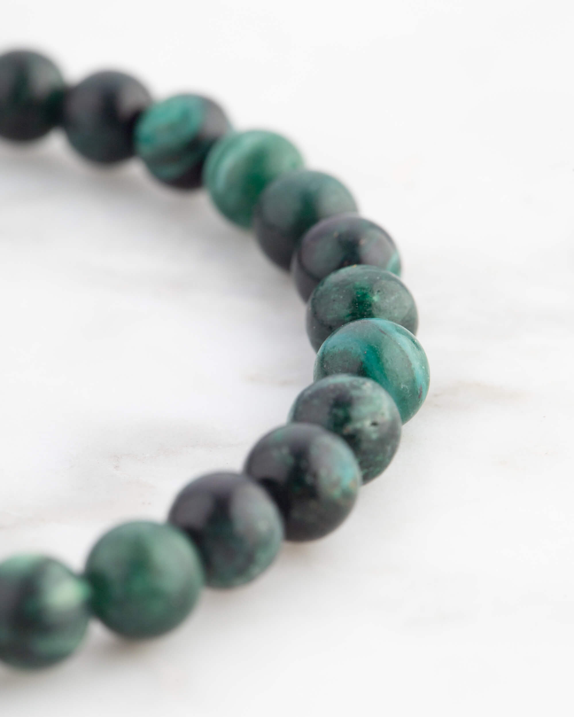 Pulsera de Esmeralda en Matriz de Biotita vista en ángulo sobre mármol claro