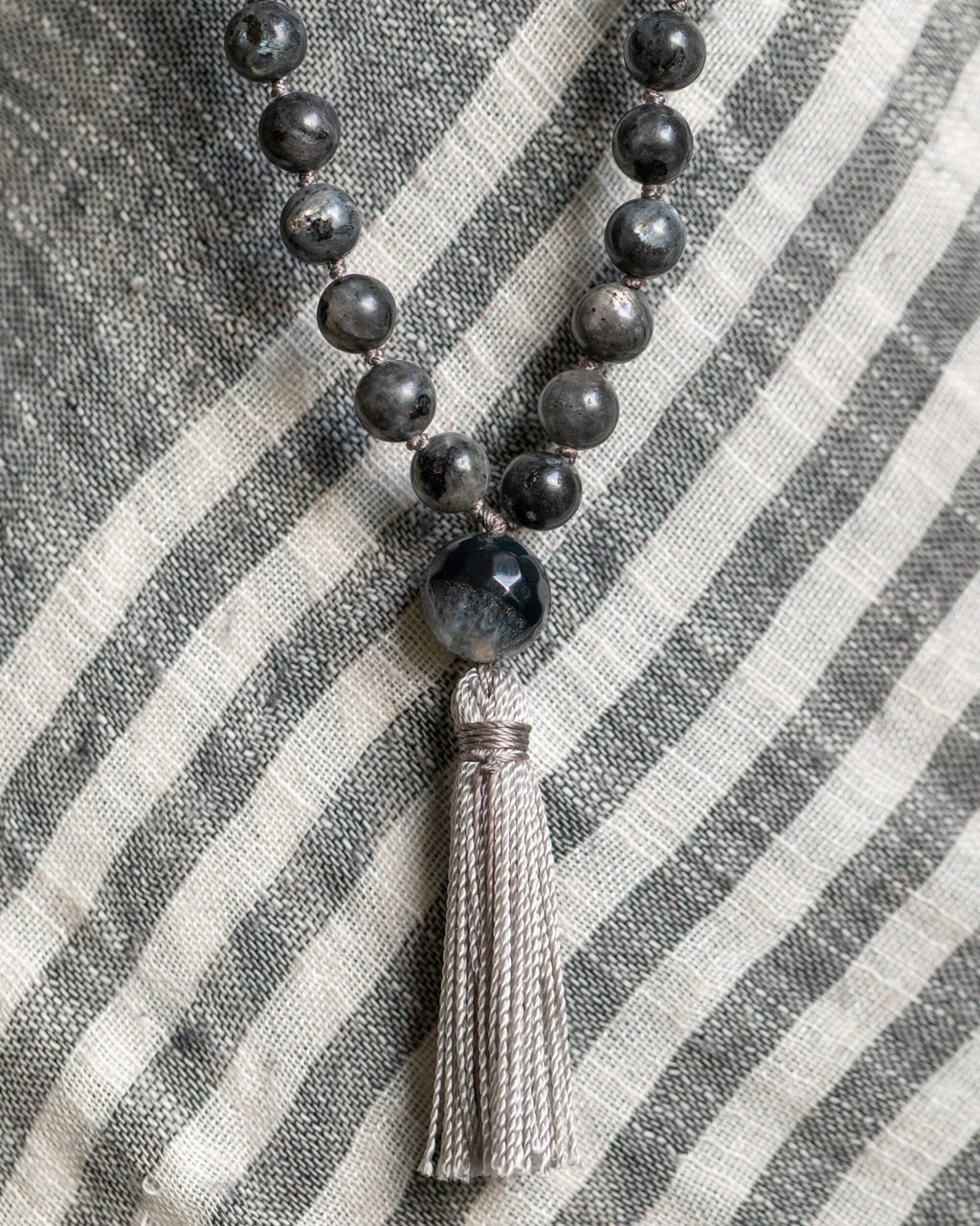Detalle macro de la cuenta guía de Ágata y borla gris del Japa Mala