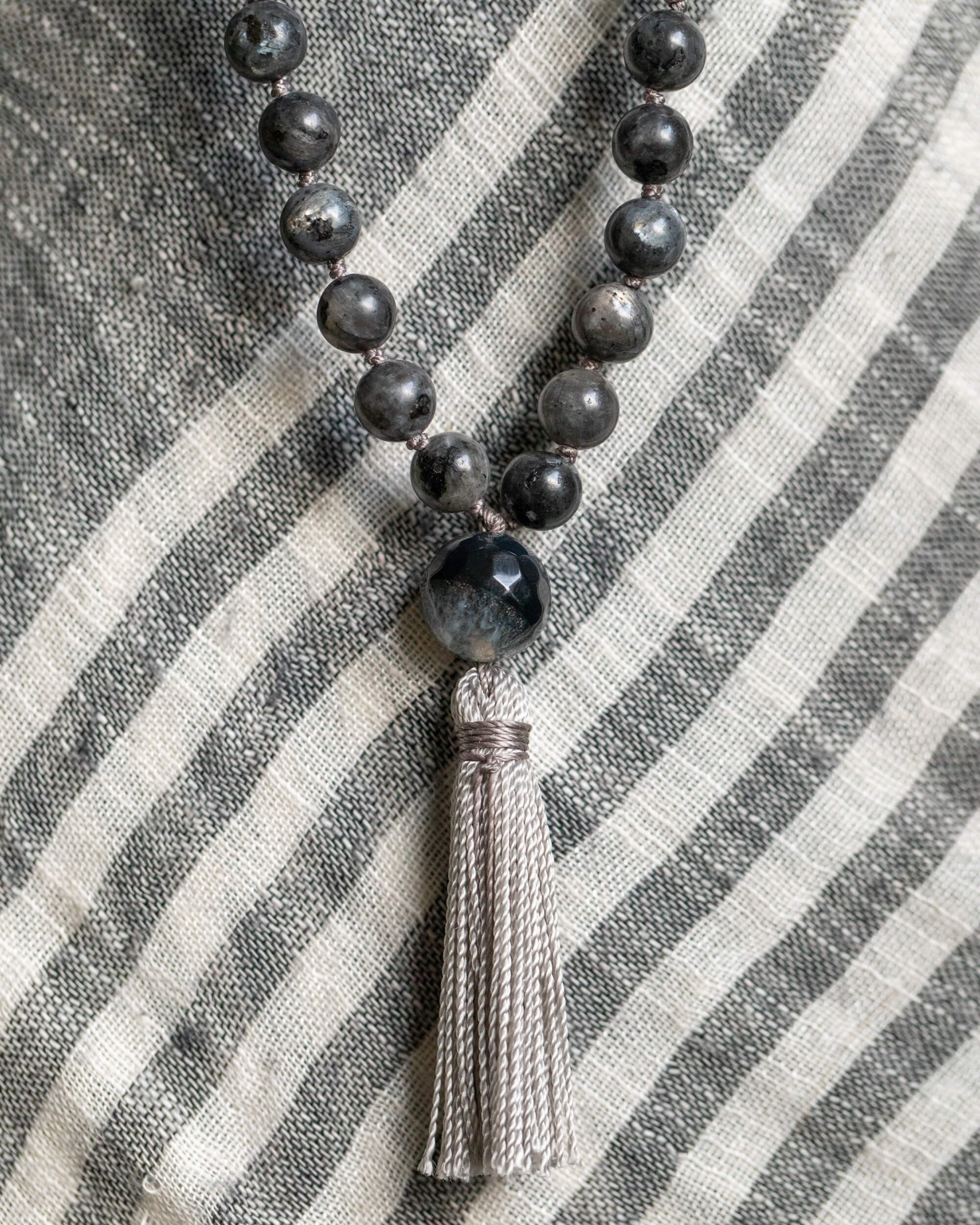 Detalle macro de la cuenta guía de Ágata y borla gris del Japa Mala