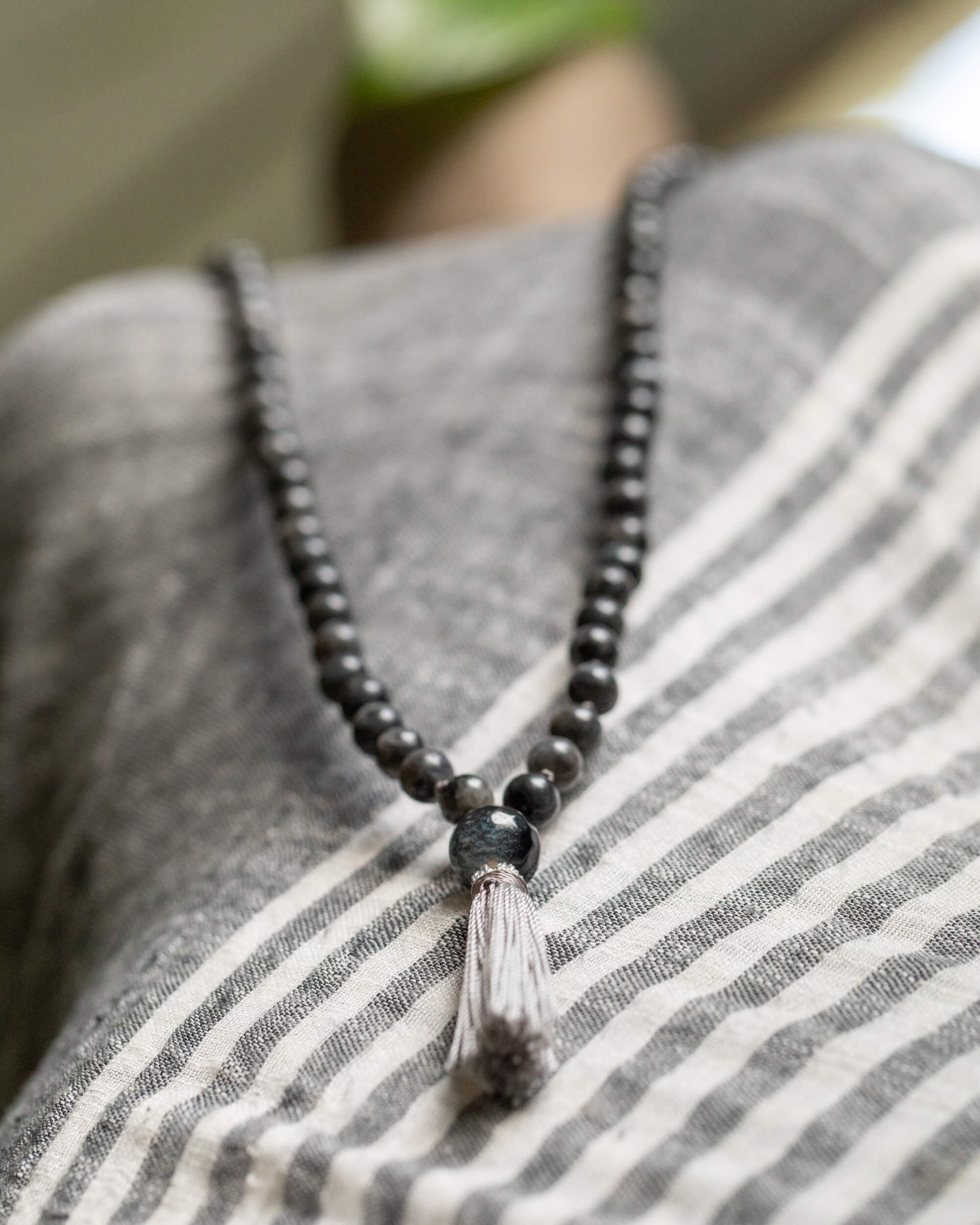 Japa Mala de Larvikita y Ágata puesto, cayendo sobre el pecho con borla gris