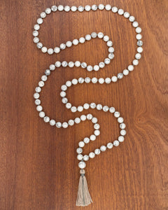 Japa Mala de Howlita, pieza completa extendida en serpentina sobre madera