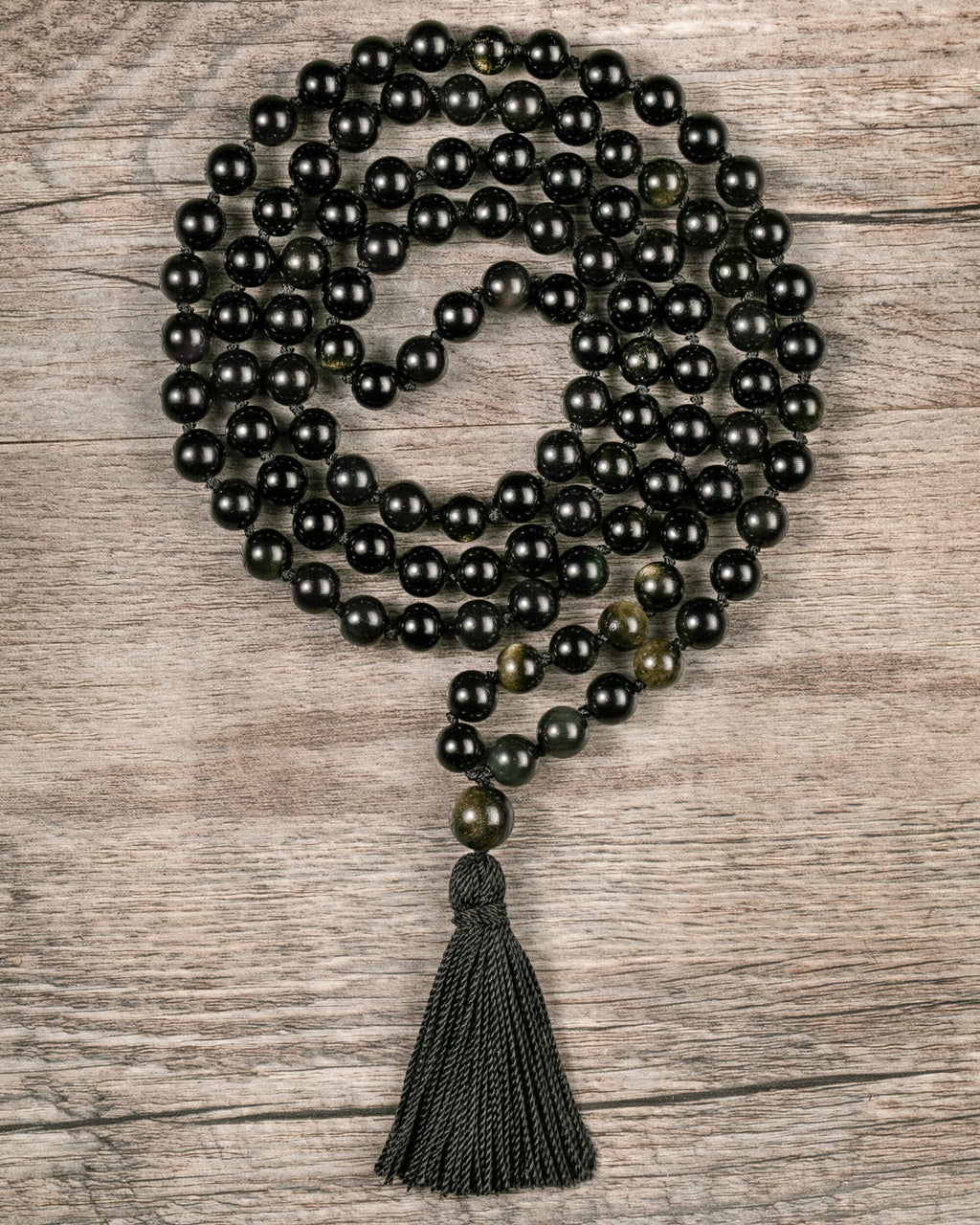 Japa Mala de Obsidiana Dorada, pieza completa enrollada sobre madera clara