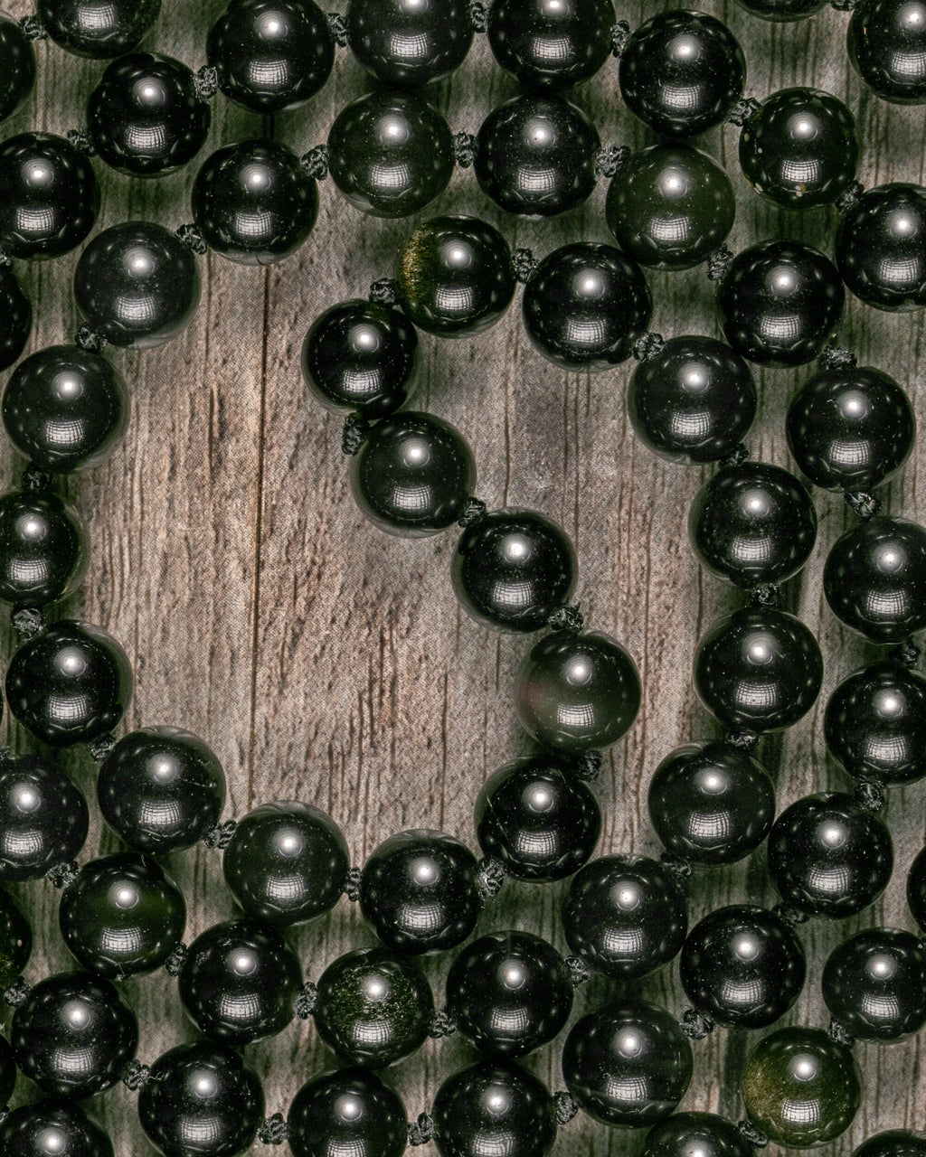 Detalle macro de las cuentas de Obsidiana Dorada con su brillo natural