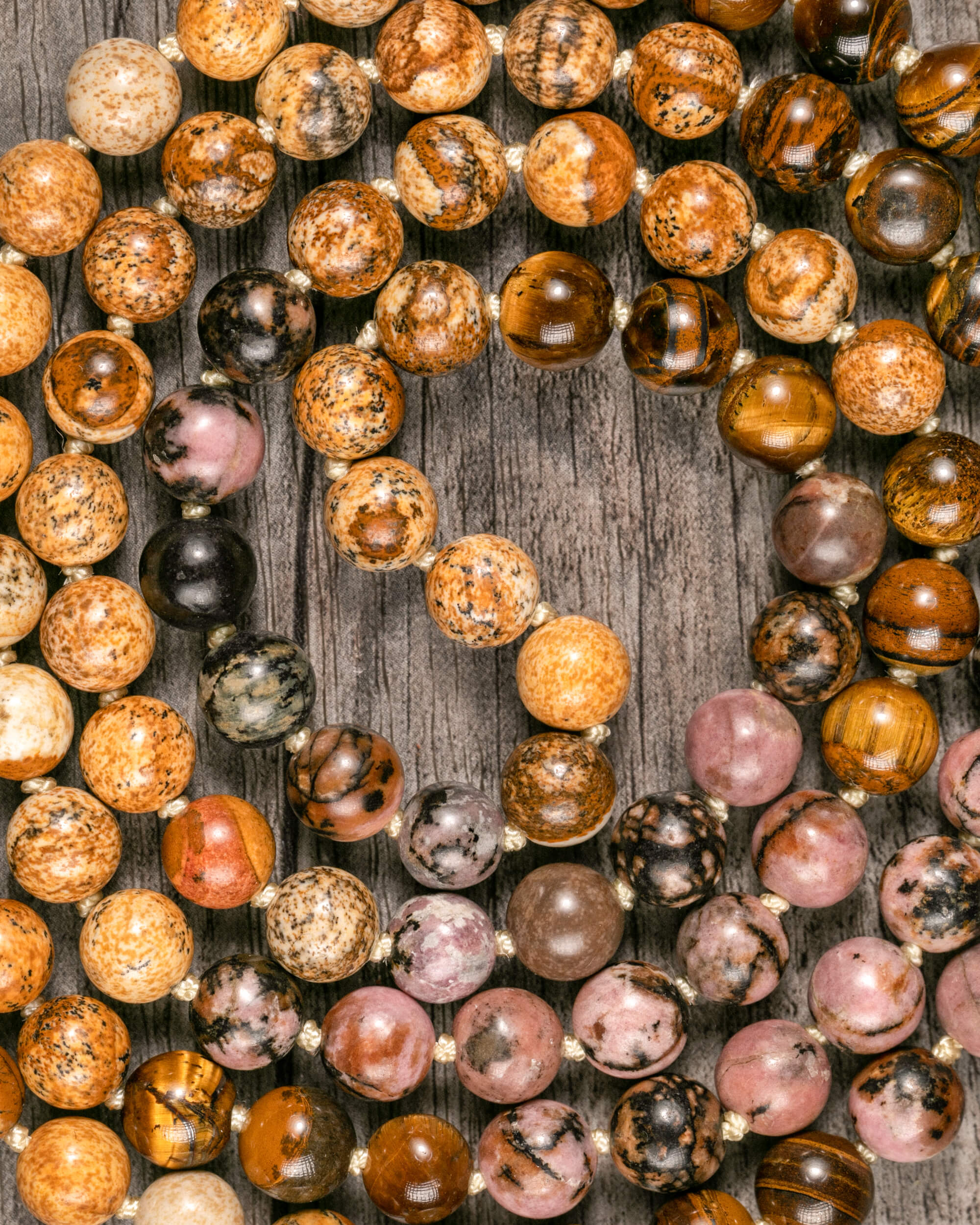 Detalle macro de las cuentas de Rodonita, Jaspe Paisaje y Ojo de Tigre