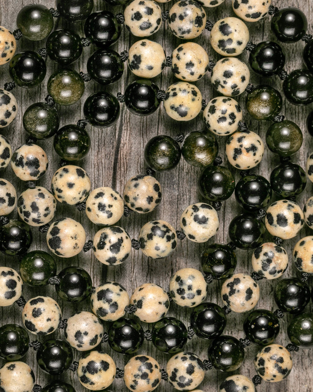 Detalle macro de las cuentas de Jaspe Dálmata y Obsidiana Dorada del Japa Mala