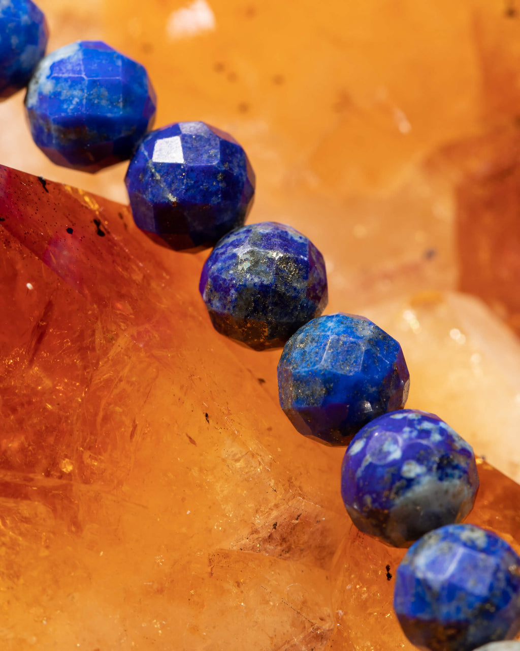 Detalle macro de las cuentas facetadas de Lapislázuli sobre cristales de citrino