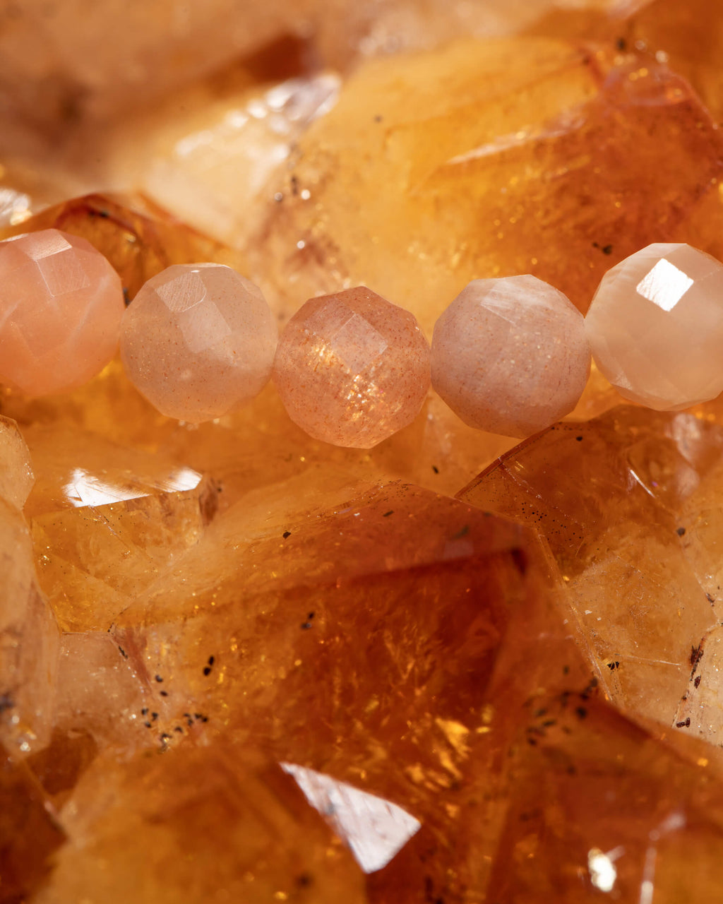 Detalle macro de las cuentas de Piedra Sol con destellos dorados sobre citrino