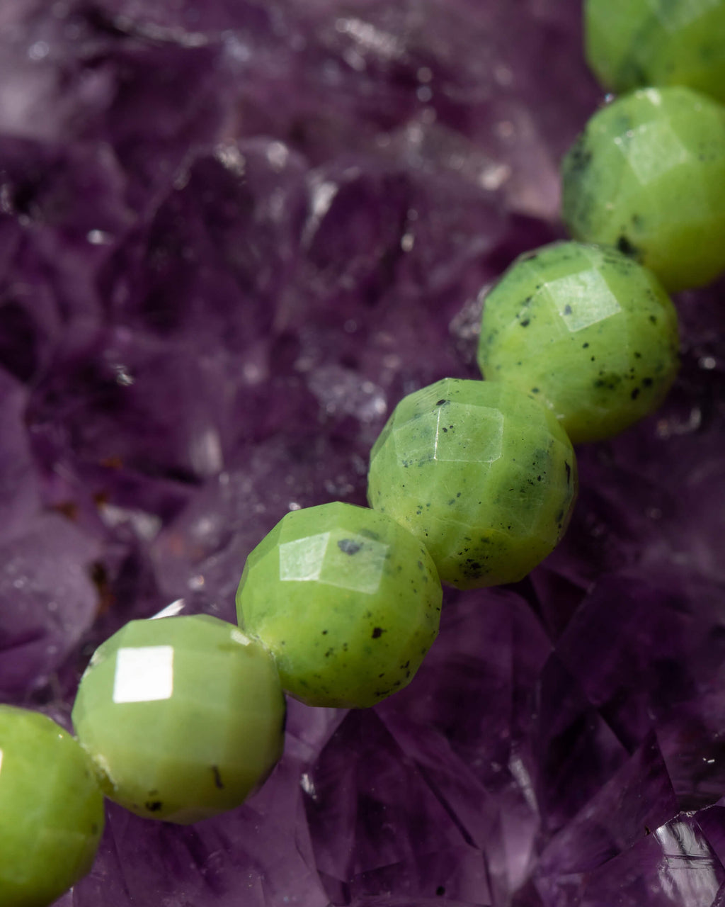 Detalle macro de las cuentas facetadas de Jade Verde sobre Amatista