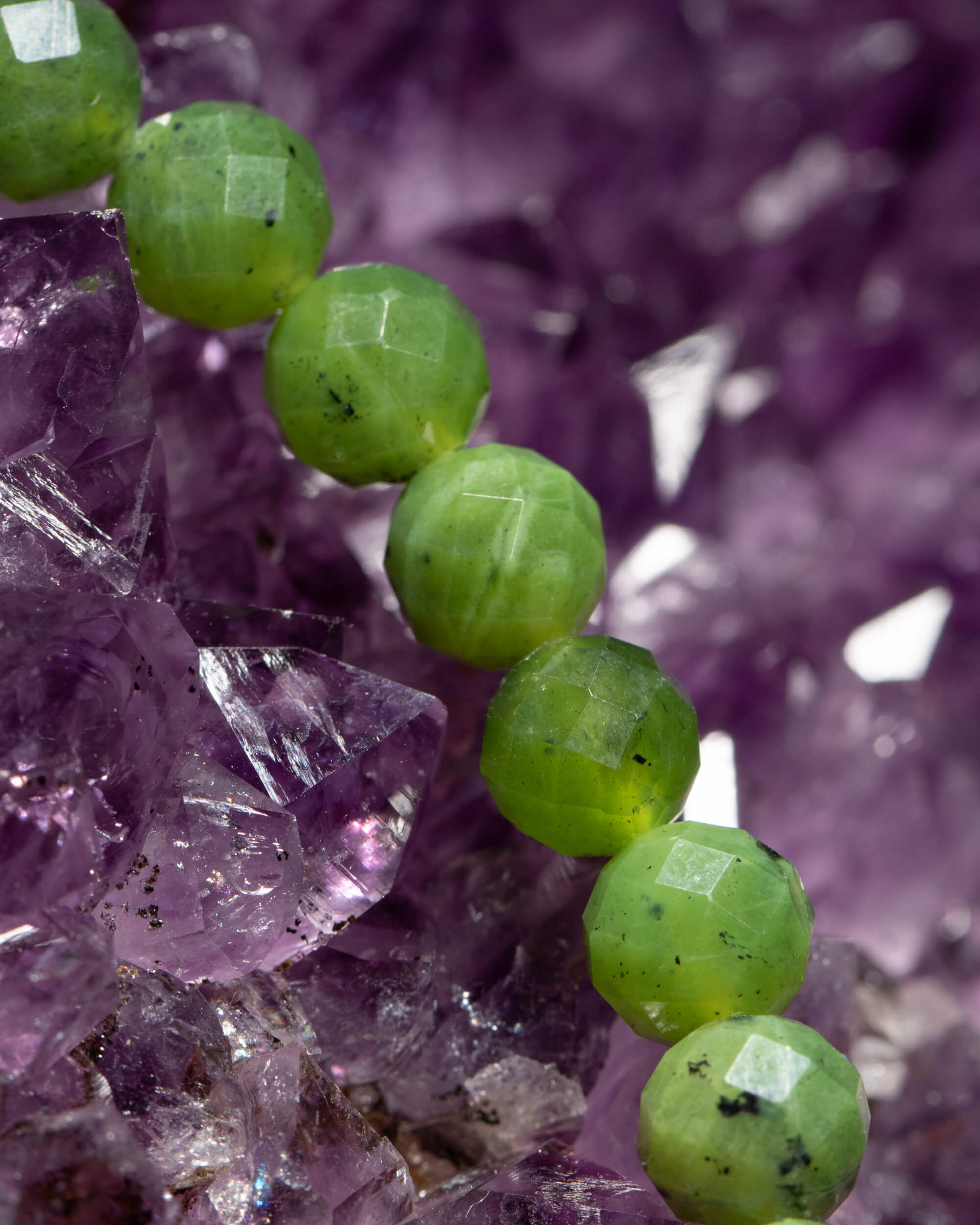 Detalle macro de las cuentas facetadas de Jade Verde sobre Amatista