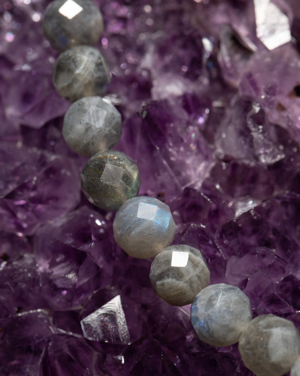Detalle macro de las cuentas facetadas de Labradorita sobre cristales de amatista