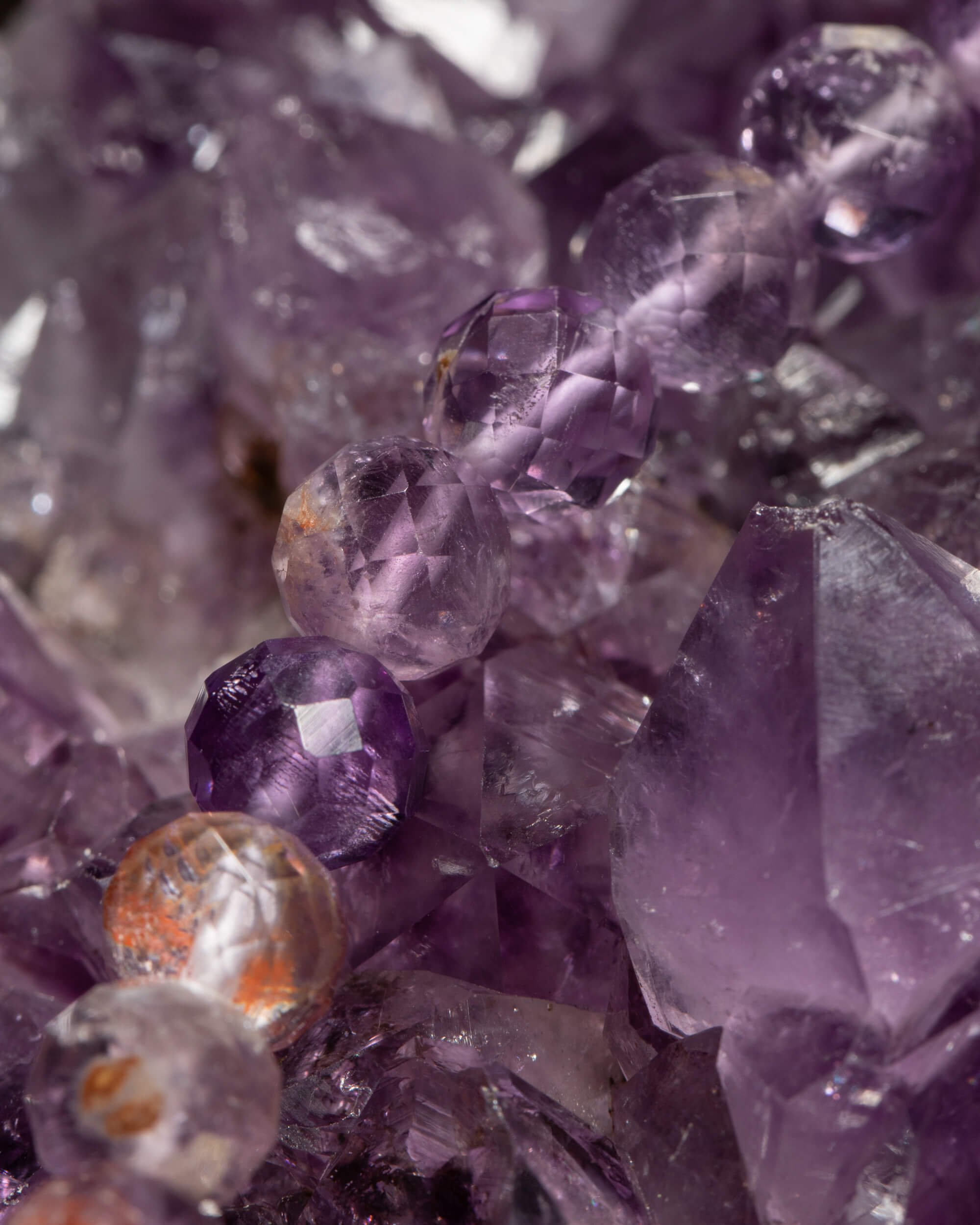 Detalle macro de las cuentas facetadas de Amatista Fantasma sobre druza de amatista