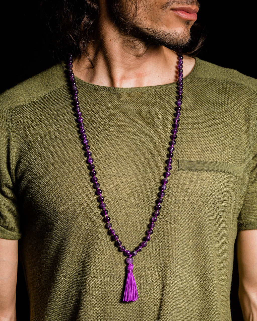 Japa Mala de Amatista puesto sobre el cuello, con borla morada visible