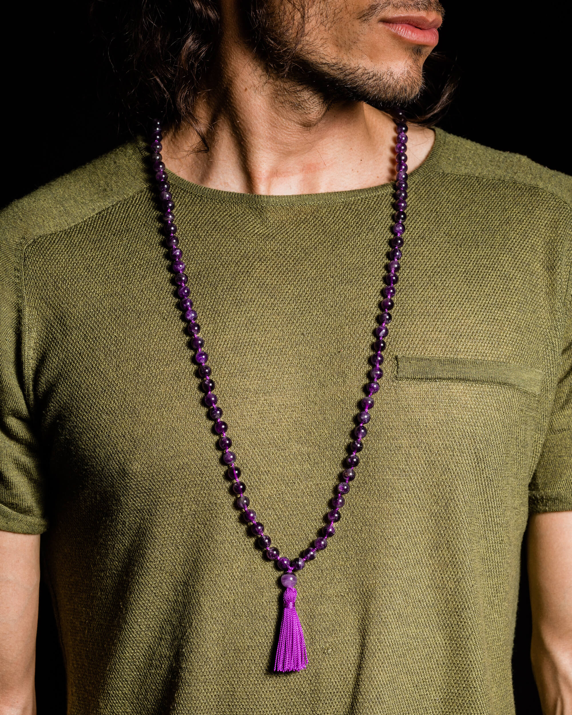 Japa Mala de Amatista puesto sobre el cuello, con borla morada visible