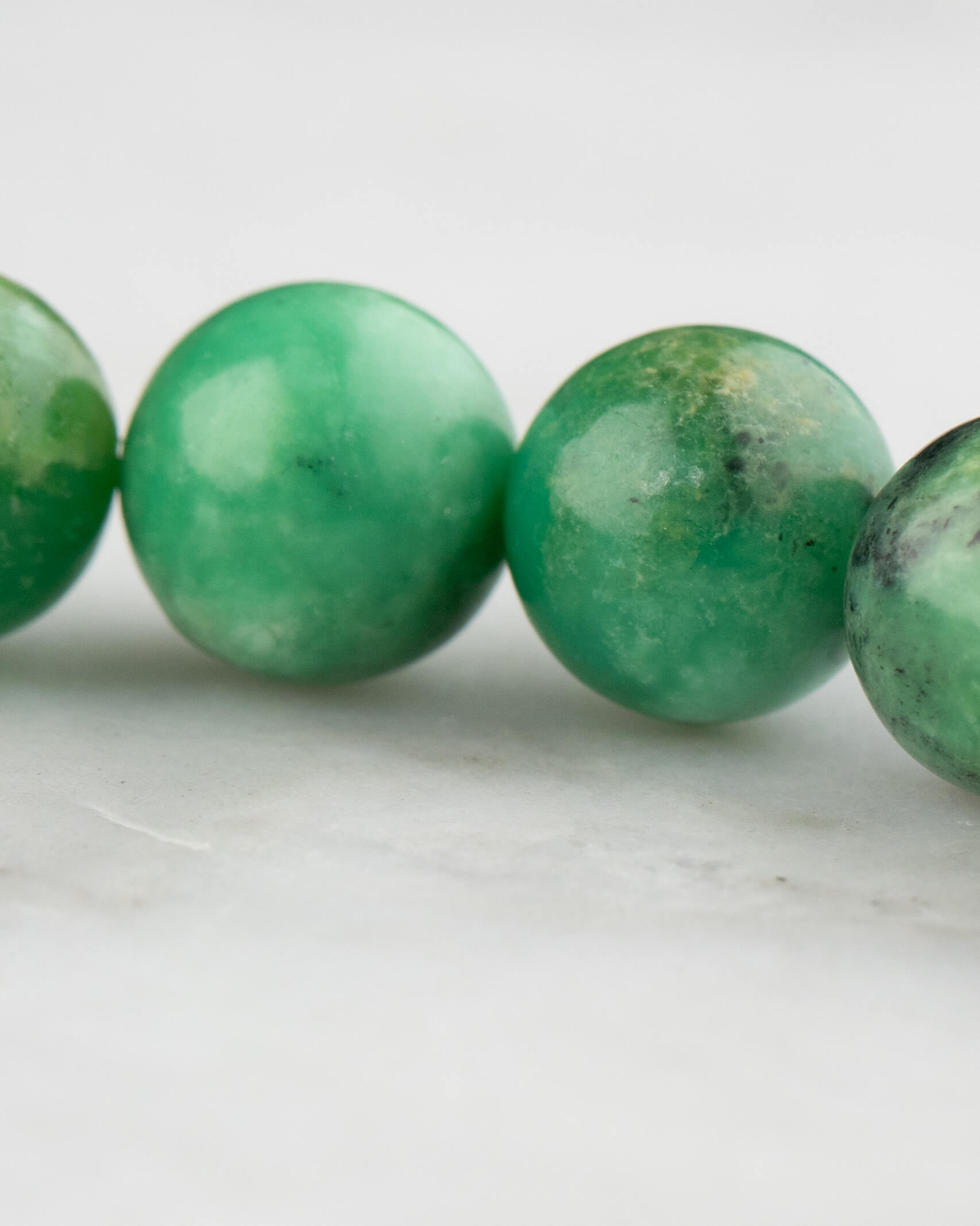 Detalle macro de las cuentas redondas de Variscita en tonos verde jade
