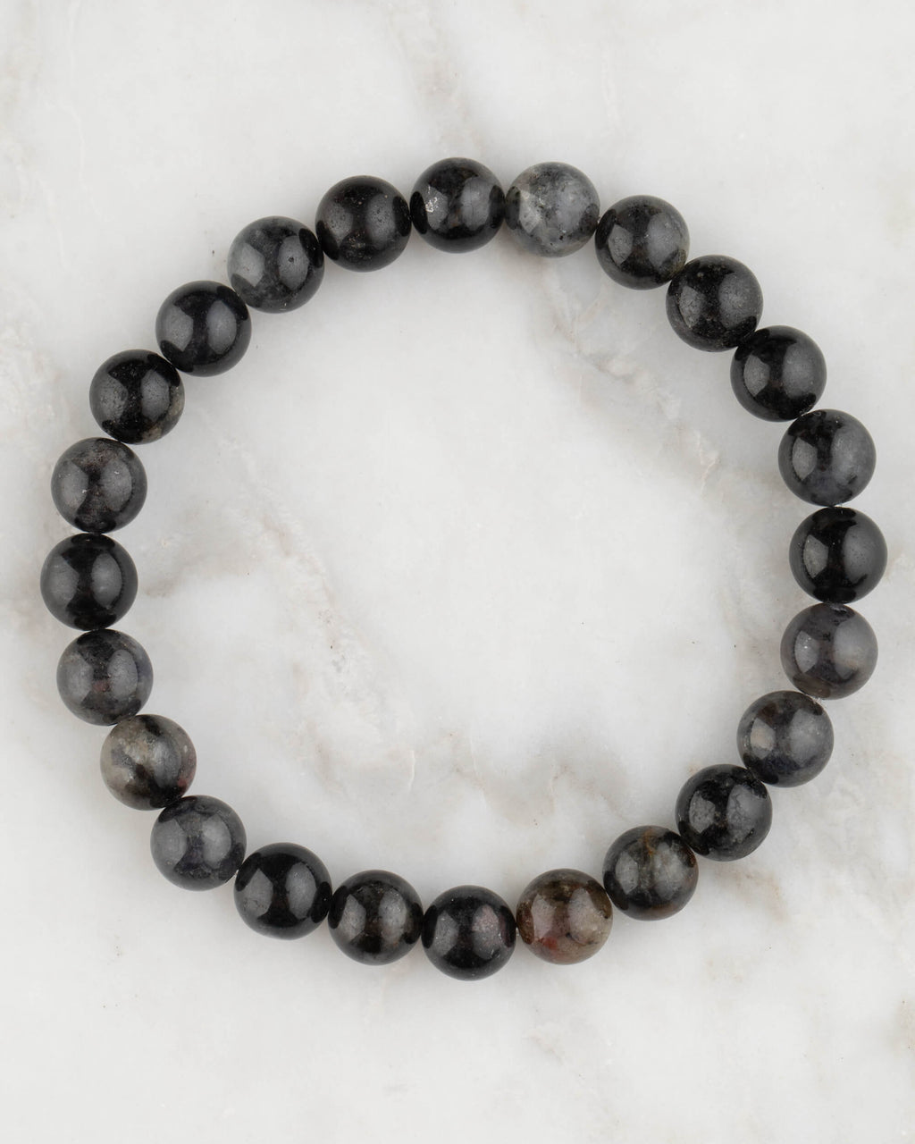 Pulsera de Iolita de 8 mm, pieza completa en círculo sobre superficie de mármol claro