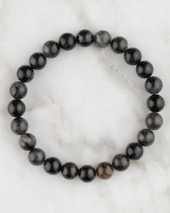 Pulsera de Iolita de 8 mm, pieza completa en círculo sobre superficie de mármol claro