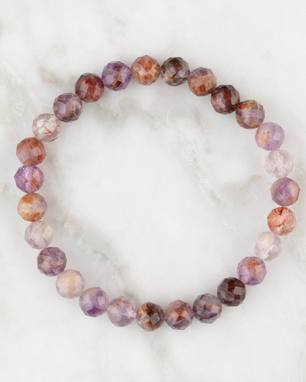 Pulsera de Amatista Fantasma facetada de 7 mm, pieza completa en círculo sobre mármol claro