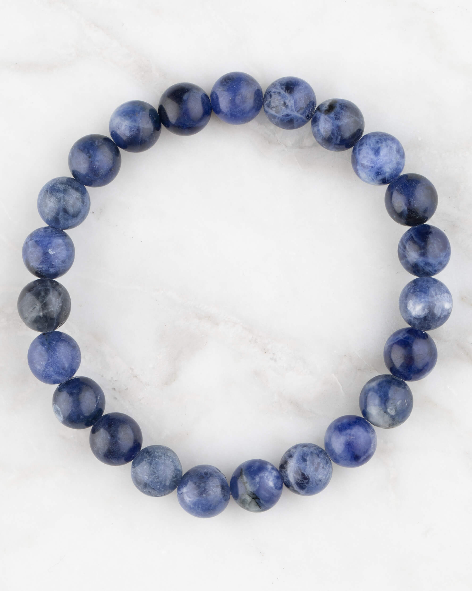 Pulsera de Sodalita de 8 mm, pieza completa en círculo sobre superficie de mármol claro