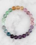 Pulsera de Fluorita Arcoiris de 8 mm, pieza completa con degradado de colores sobre mármol claro