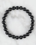 Pulsera de Shungita de 8 mm, pieza completa en círculo sobre mármol claro