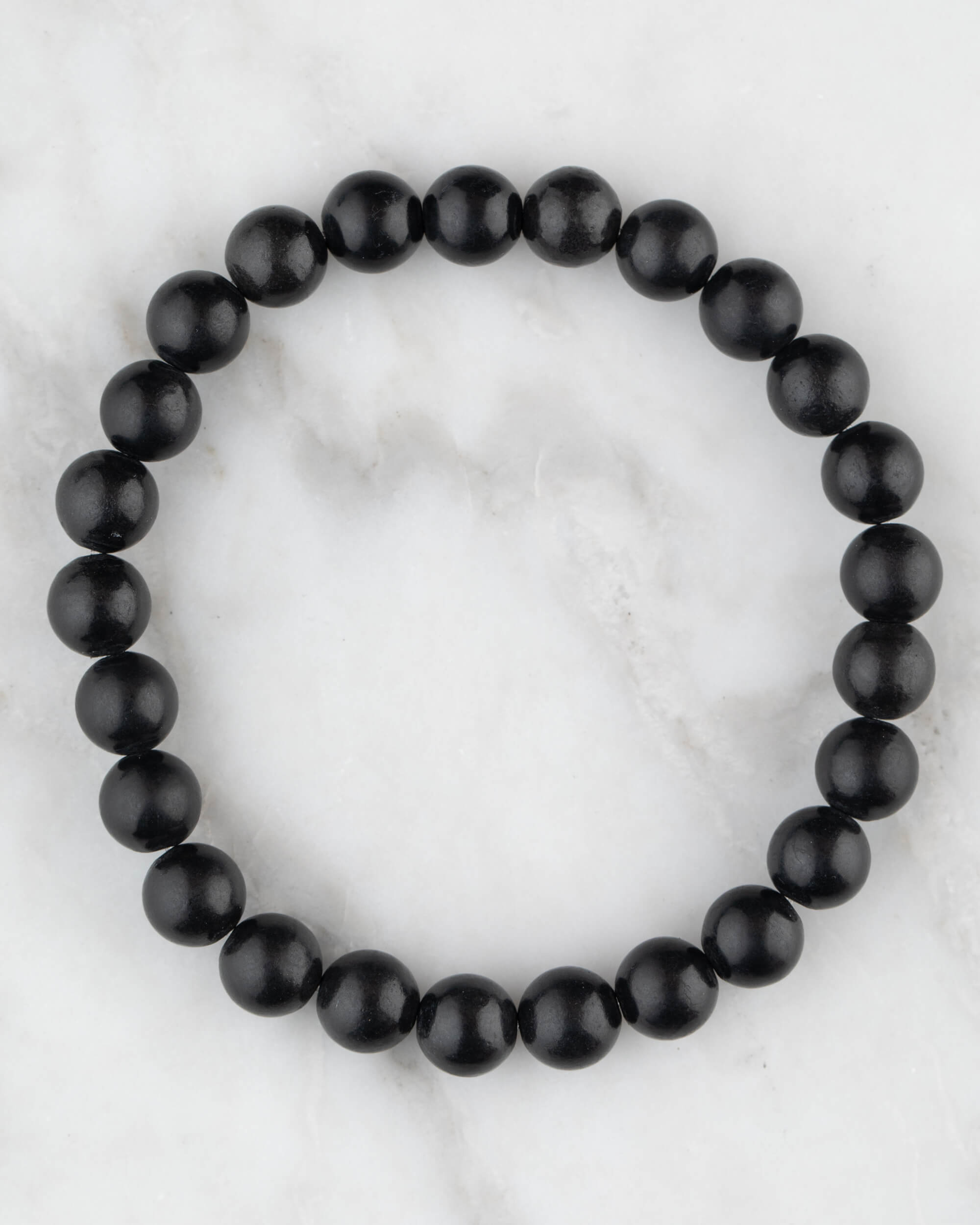 Pulsera de Shungita de 8 mm, pieza completa en círculo sobre mármol claro