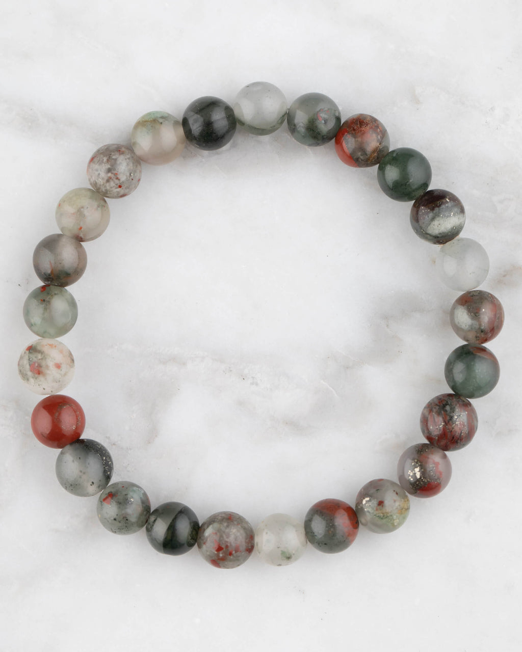 Pulsera de Piedra Sangre de 8 mm, pieza completa en círculo sobre superficie de mármol claro