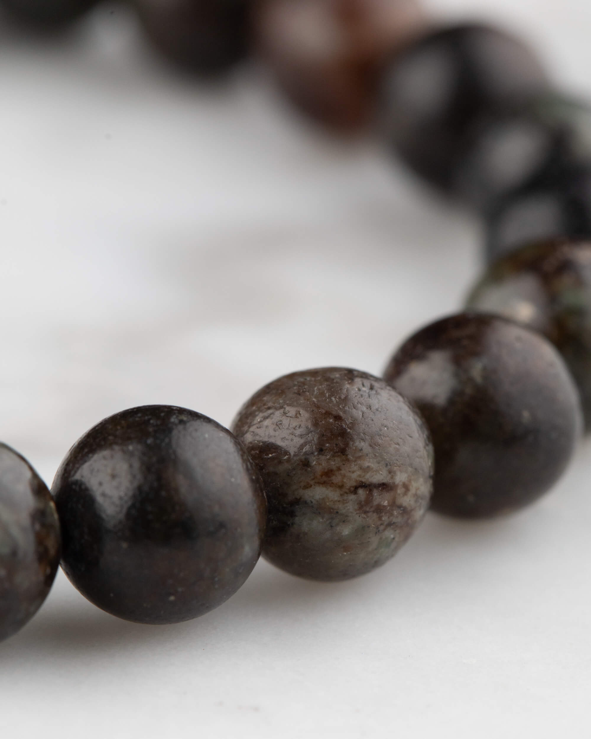 Pulsera de Flogopita vista en curva, cuentas negras y marrones con degradado de enfoque