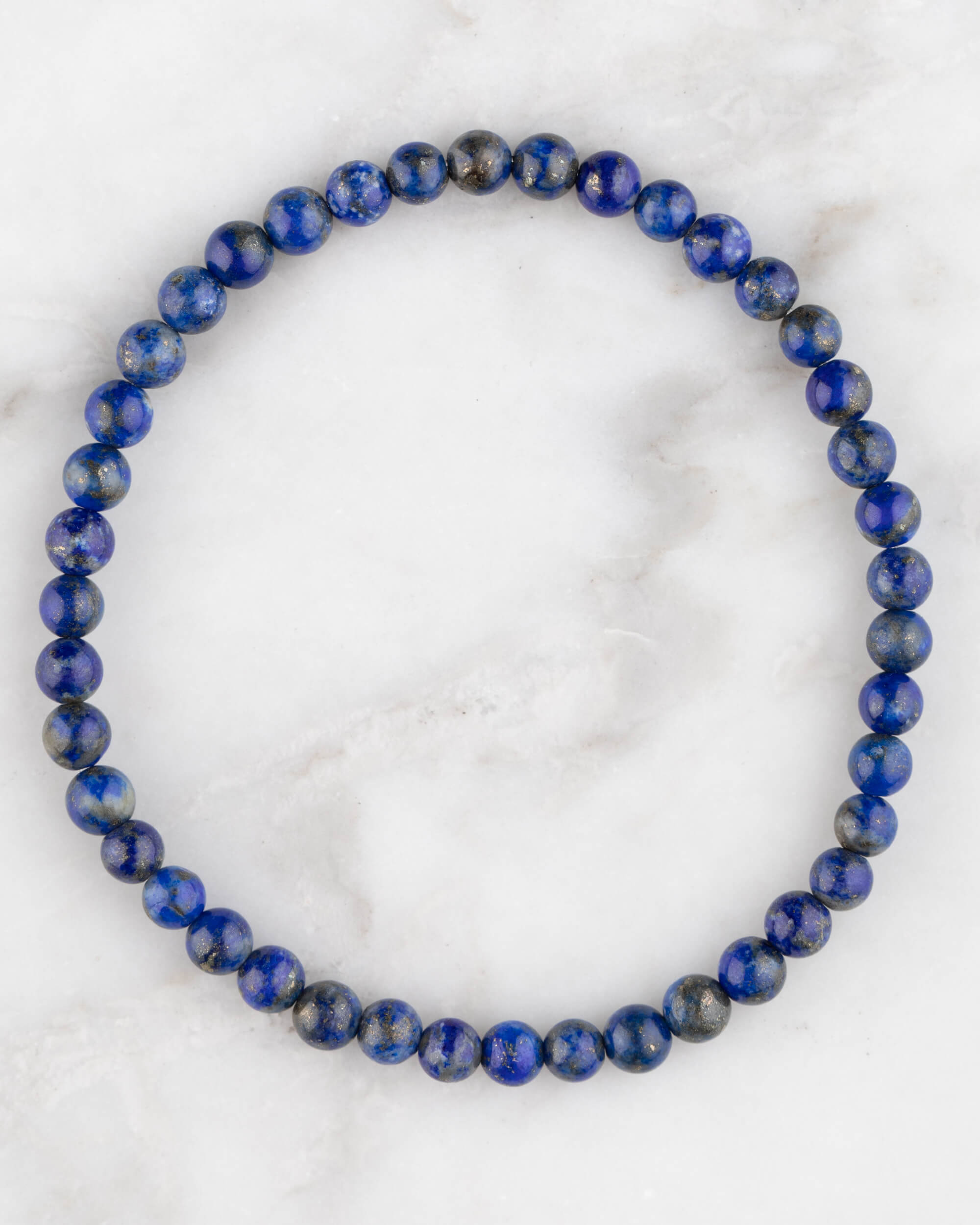 Pulsera de Lapislázuli de 4 mm, pieza completa en círculo sobre mármol claro