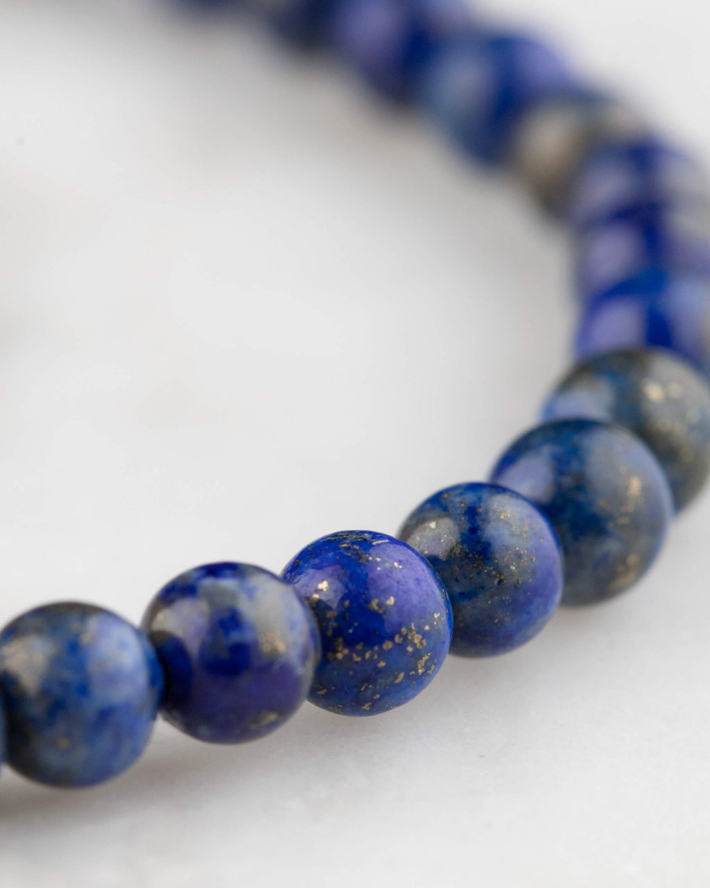 Pulsera de Lapislázuli vista en curva, cuentas azul intenso con vetas doradas de pirita