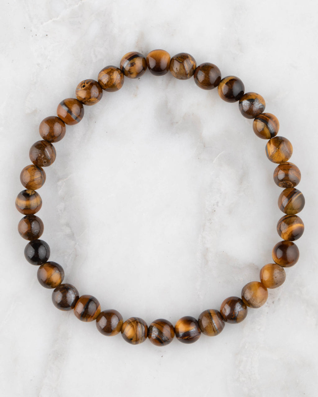 Pulsera de Ojo de Tigre de 6 mm, pieza completa en círculo sobre superficie de mármol claro