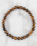 Pulsera de Ojo de Tigre de 6 mm, pieza completa en círculo sobre superficie de mármol claro