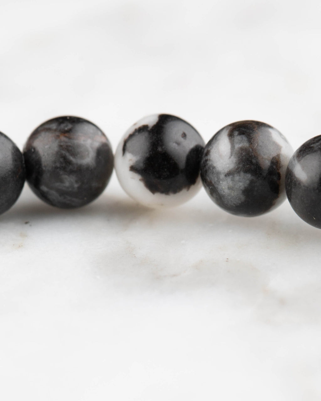 Detalle macro de cuentas de Jaspe Cebra con rayas negras y blancas