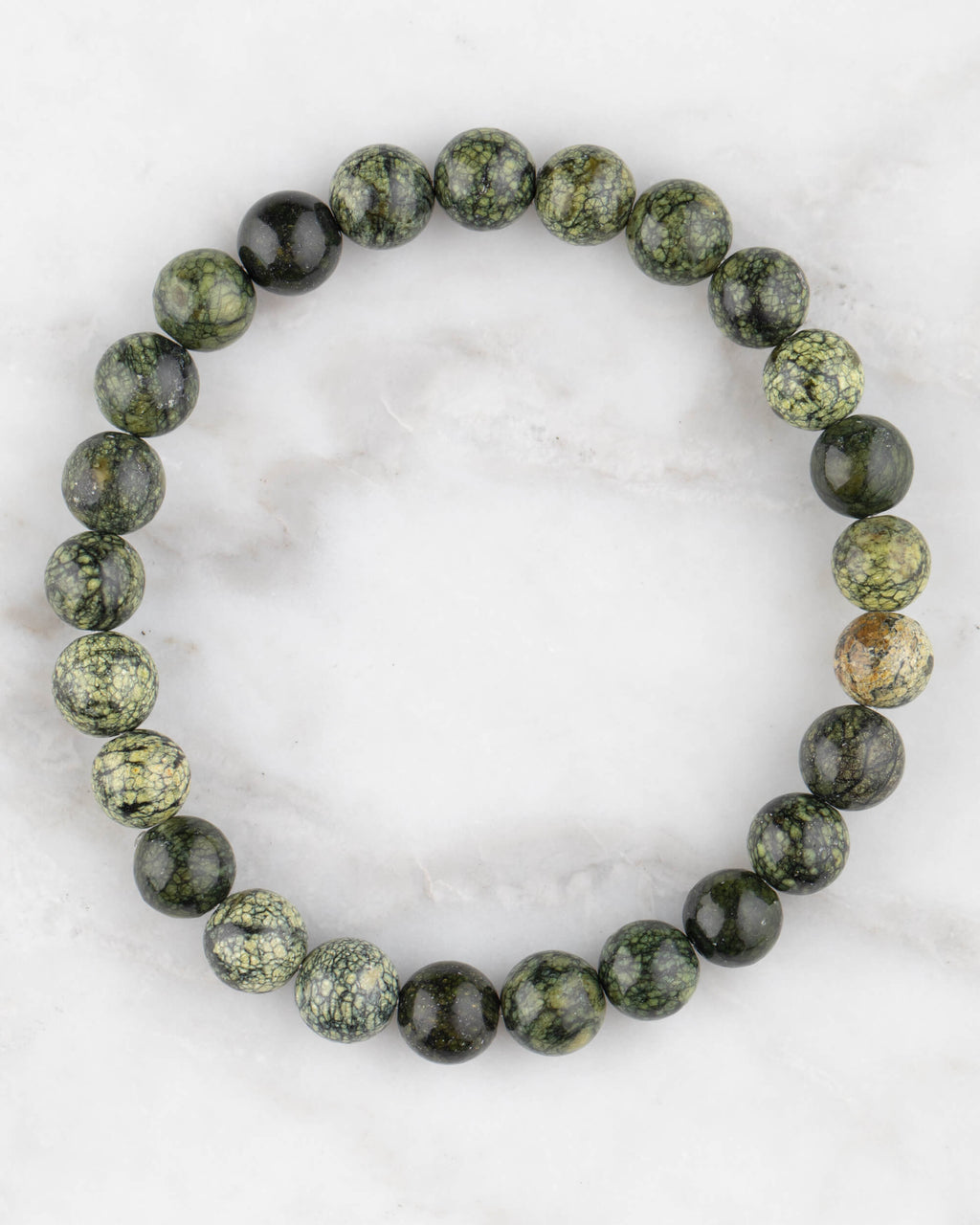 Pulsera de Serpentina de 8 mm, pieza completa en círculo sobre mármol claro