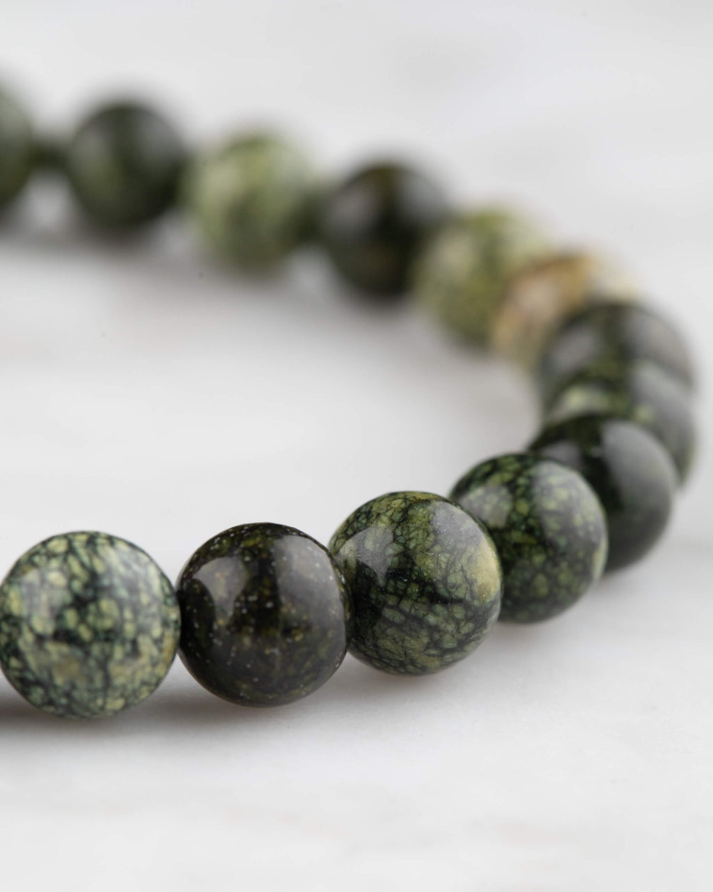Pulsera de Serpentina vista en angulo, cuentas verdes con patron moteado