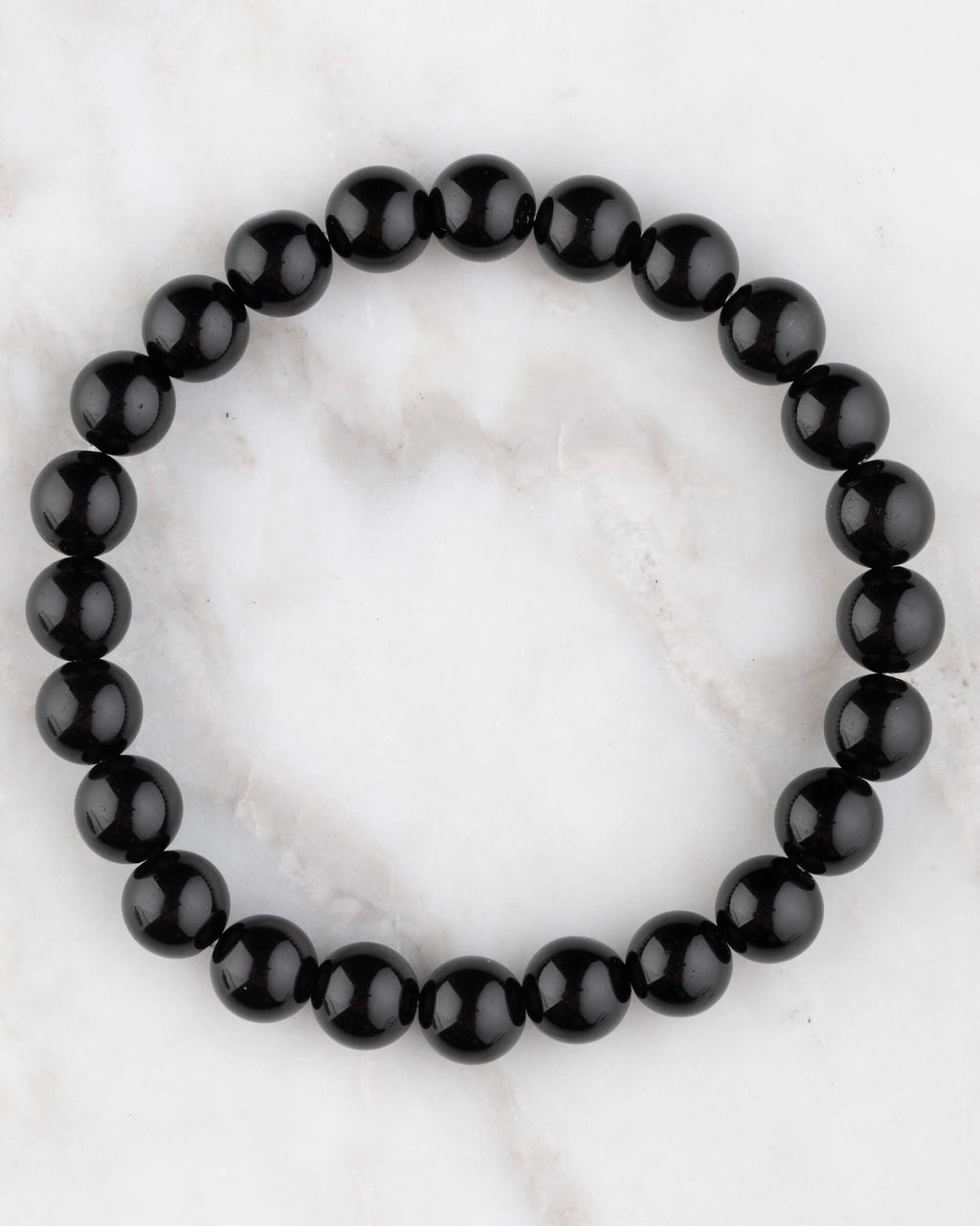 Pulsera de Obsidiana Negra de 8 mm, pieza completa en círculo sobre mármol claro