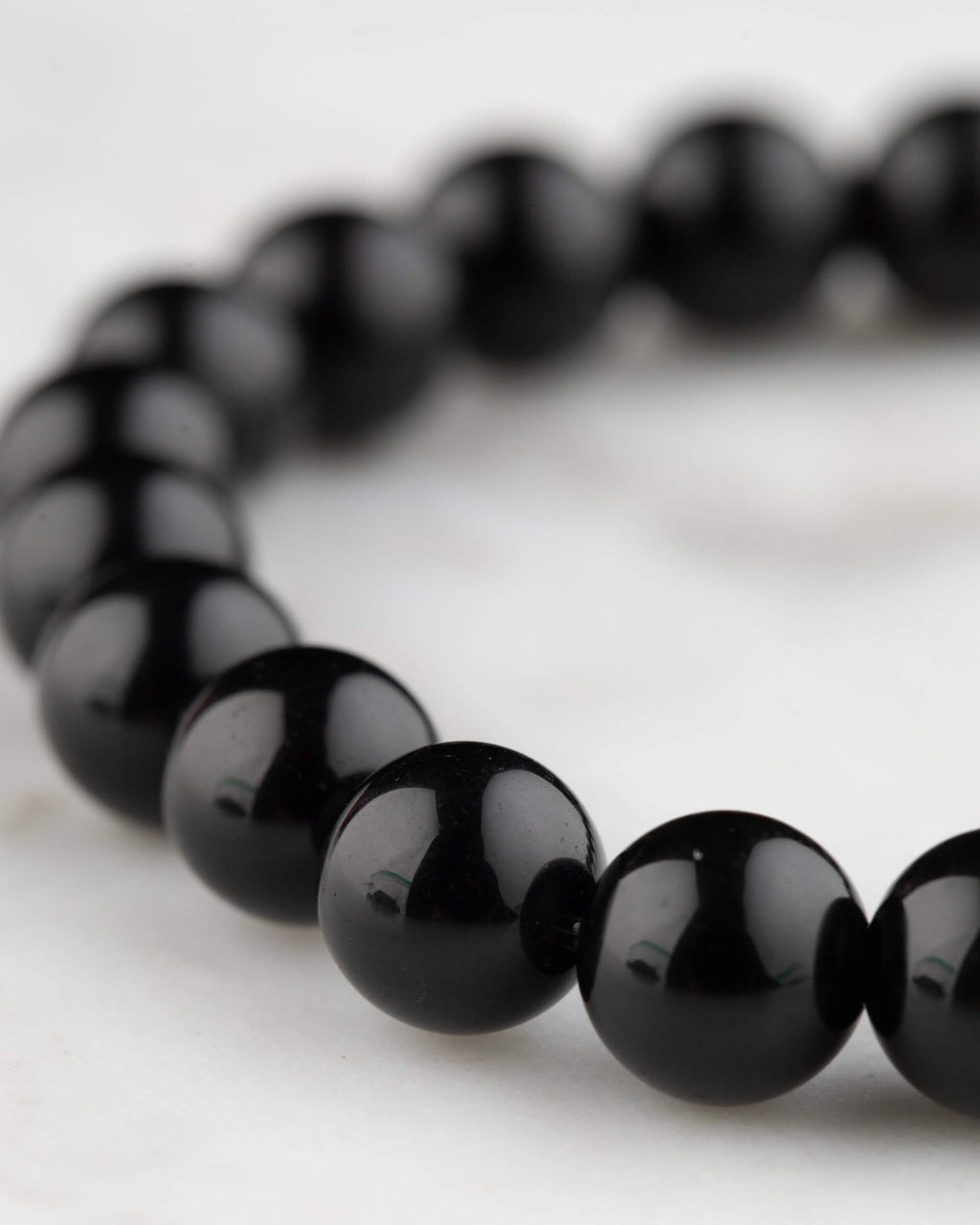 Pulsera de Obsidiana Negra vista en angulo, cuentas brillantes y uniformes