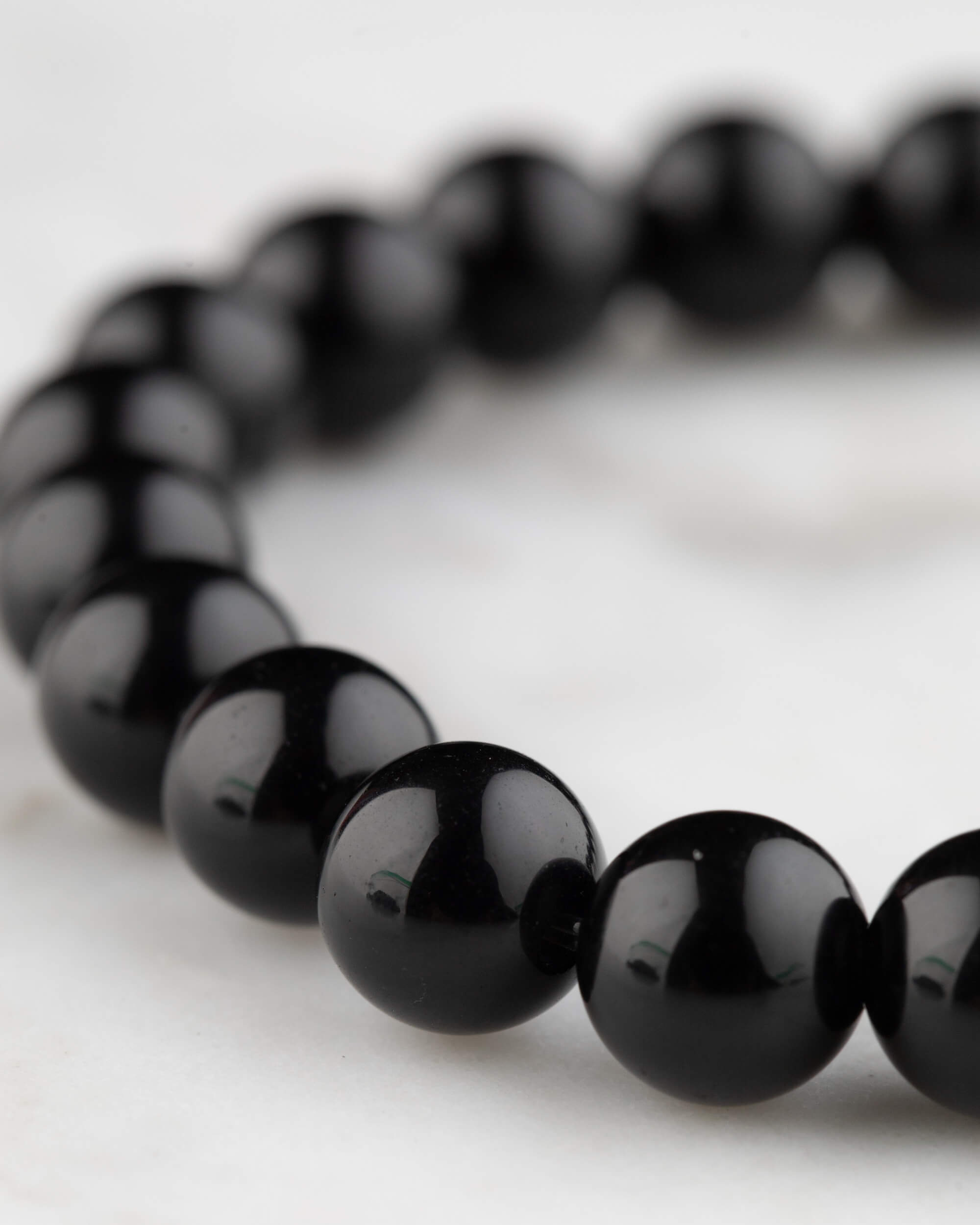 Pulsera de Obsidiana Negra vista en angulo, cuentas brillantes y uniformes