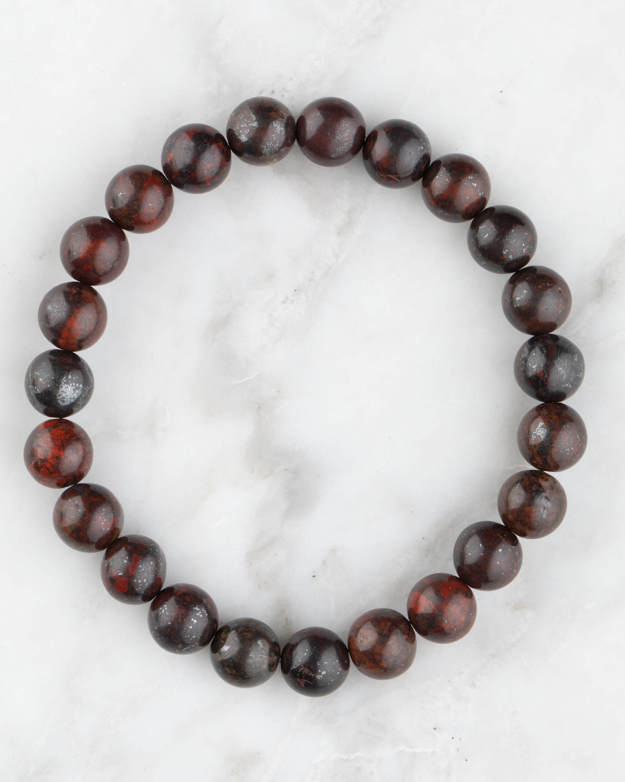 Pulsera de Jaspe Rojo Oscuro de 8 mm, pieza completa en círculo sobre mármol claro