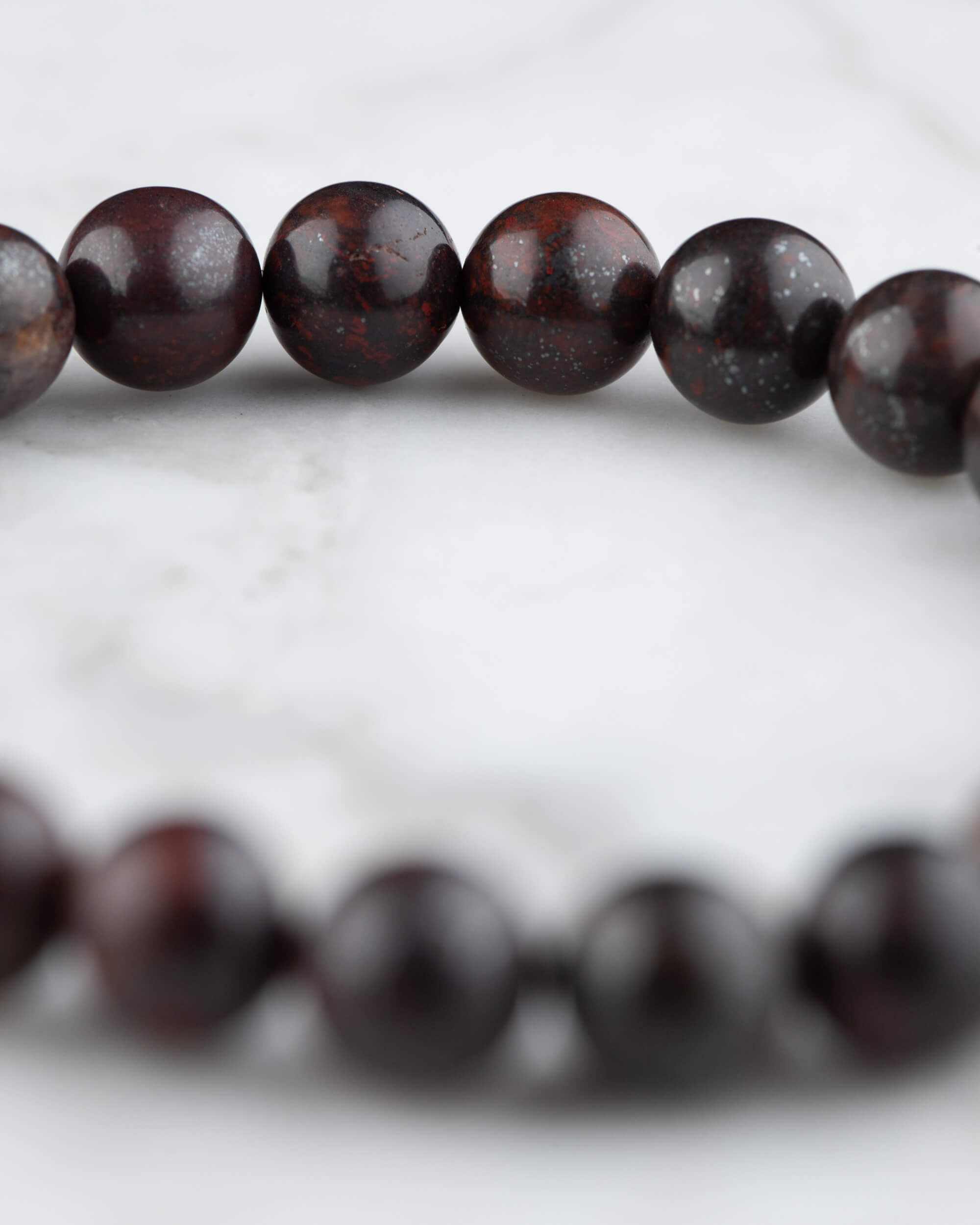 Pulsera de Jaspe Rojo Oscuro vista de cerca en angulo, cuentas con brillo natural