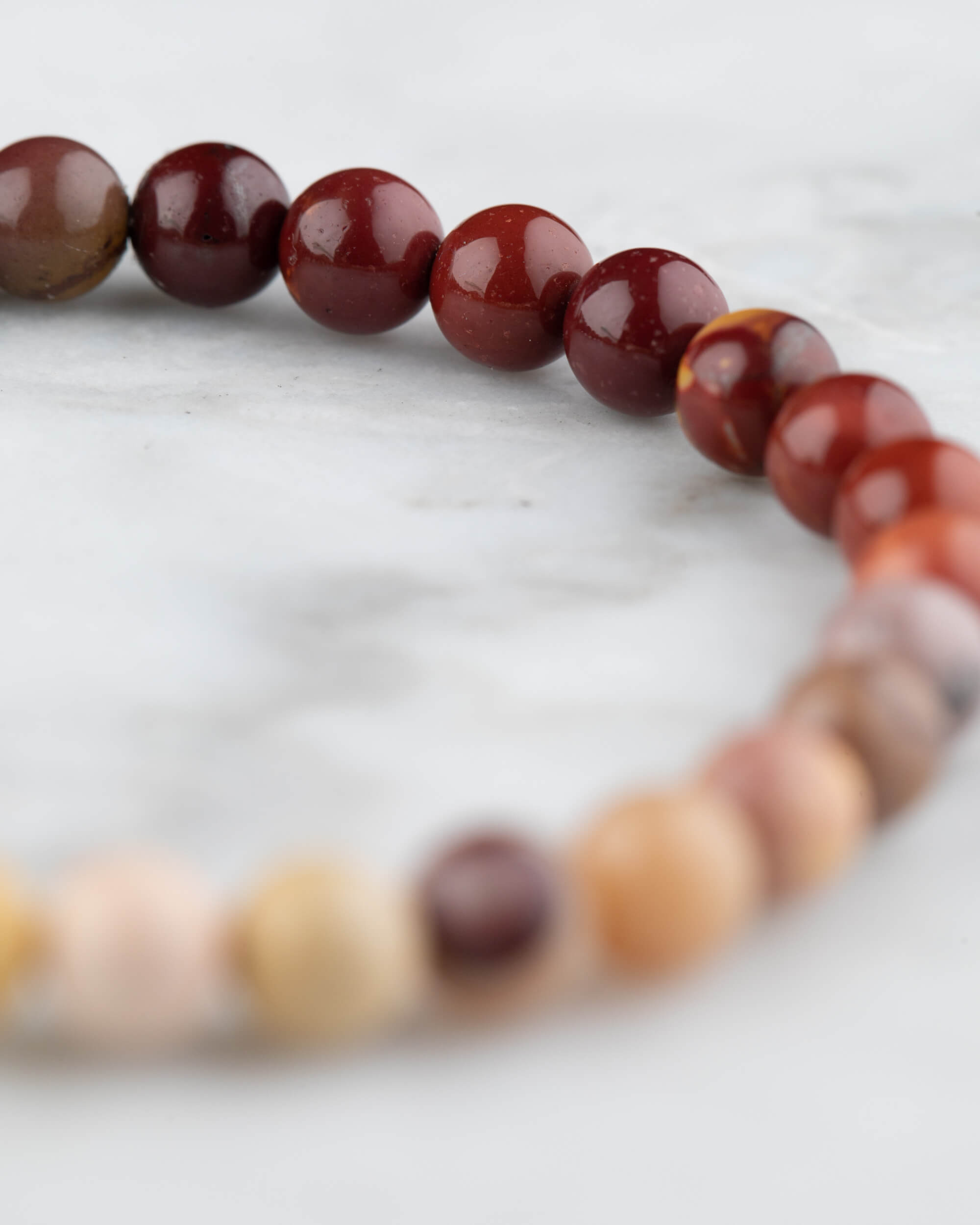 Pulsera de Jaspe Mokaita en perspectiva curva con tonos rojizos y ocres