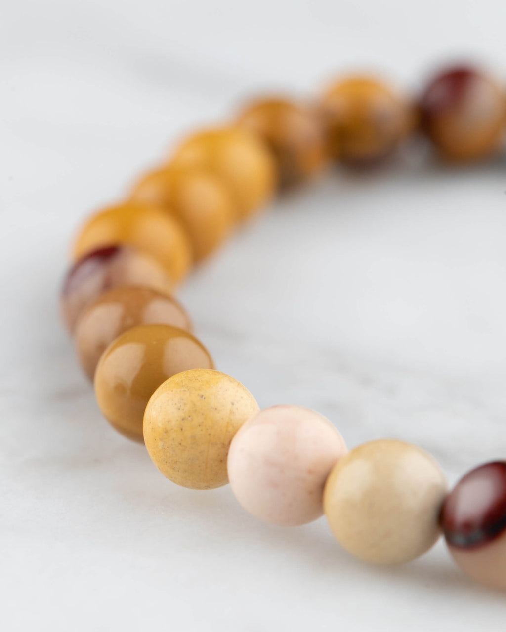 Pulsera de Jaspe Mokaita en perspectiva curva sobre mármol claro