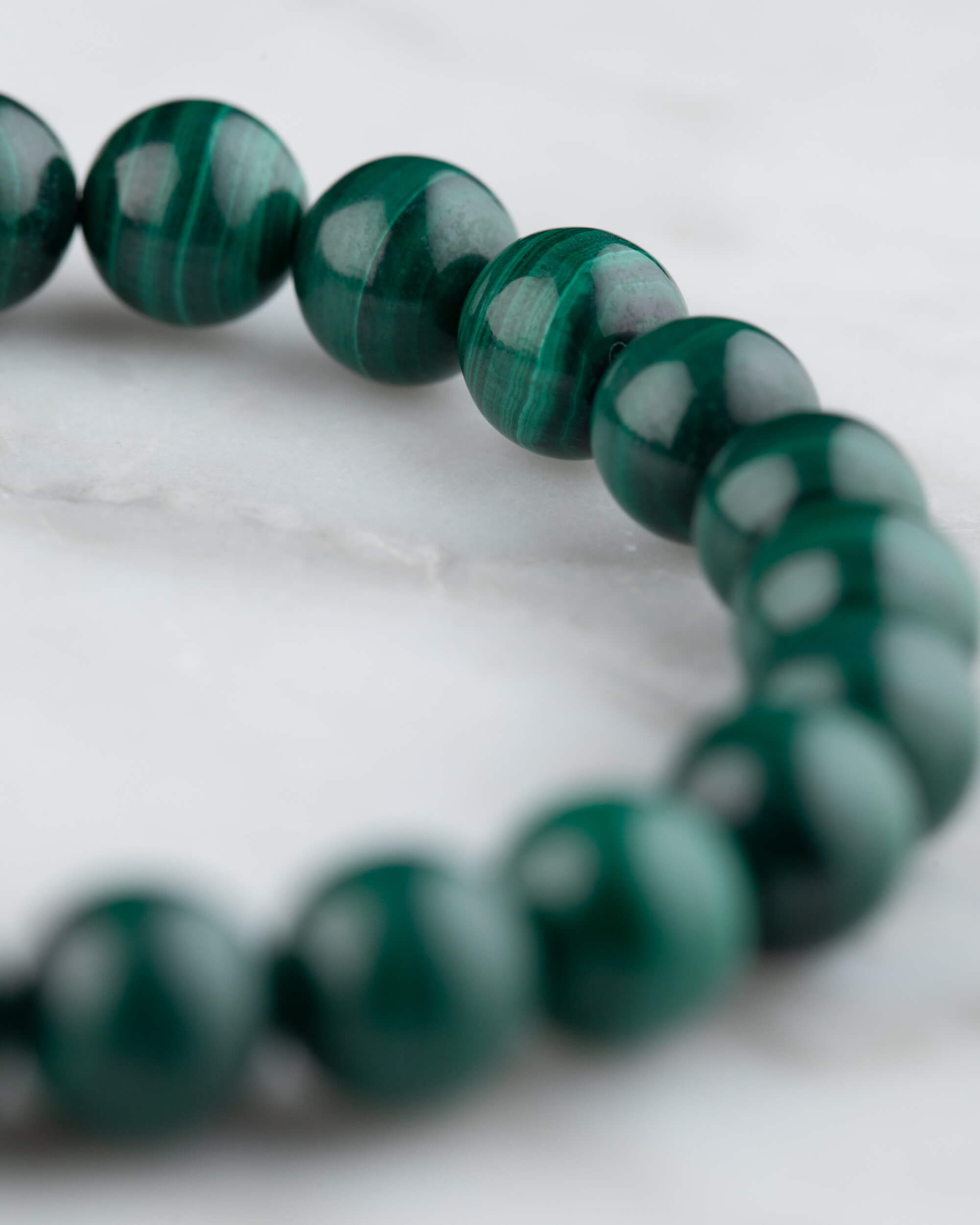 Pulsera de Malaquita en perspectiva circular sobre mármol claro