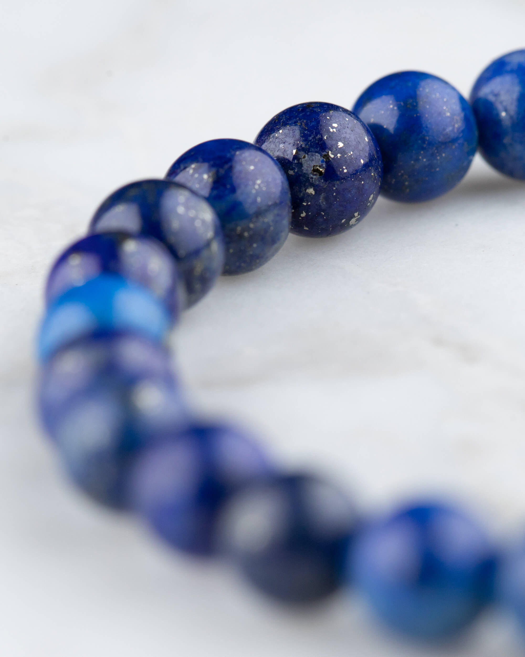 Pulsera de Lapislázuli en perspectiva circular sobre mármol claro