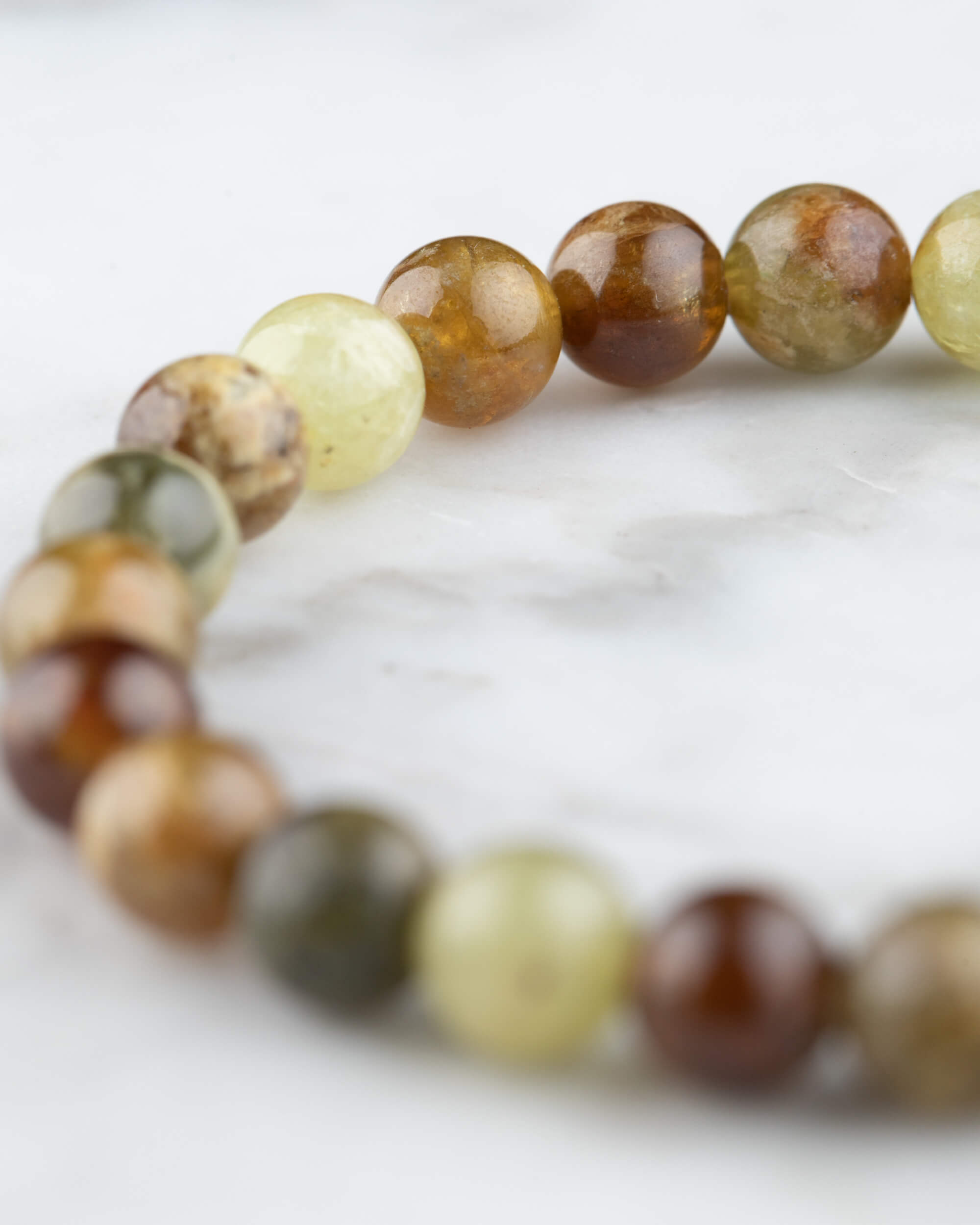 Pulsera de Granate Grosularia en perspectiva circular sobre mármol claro