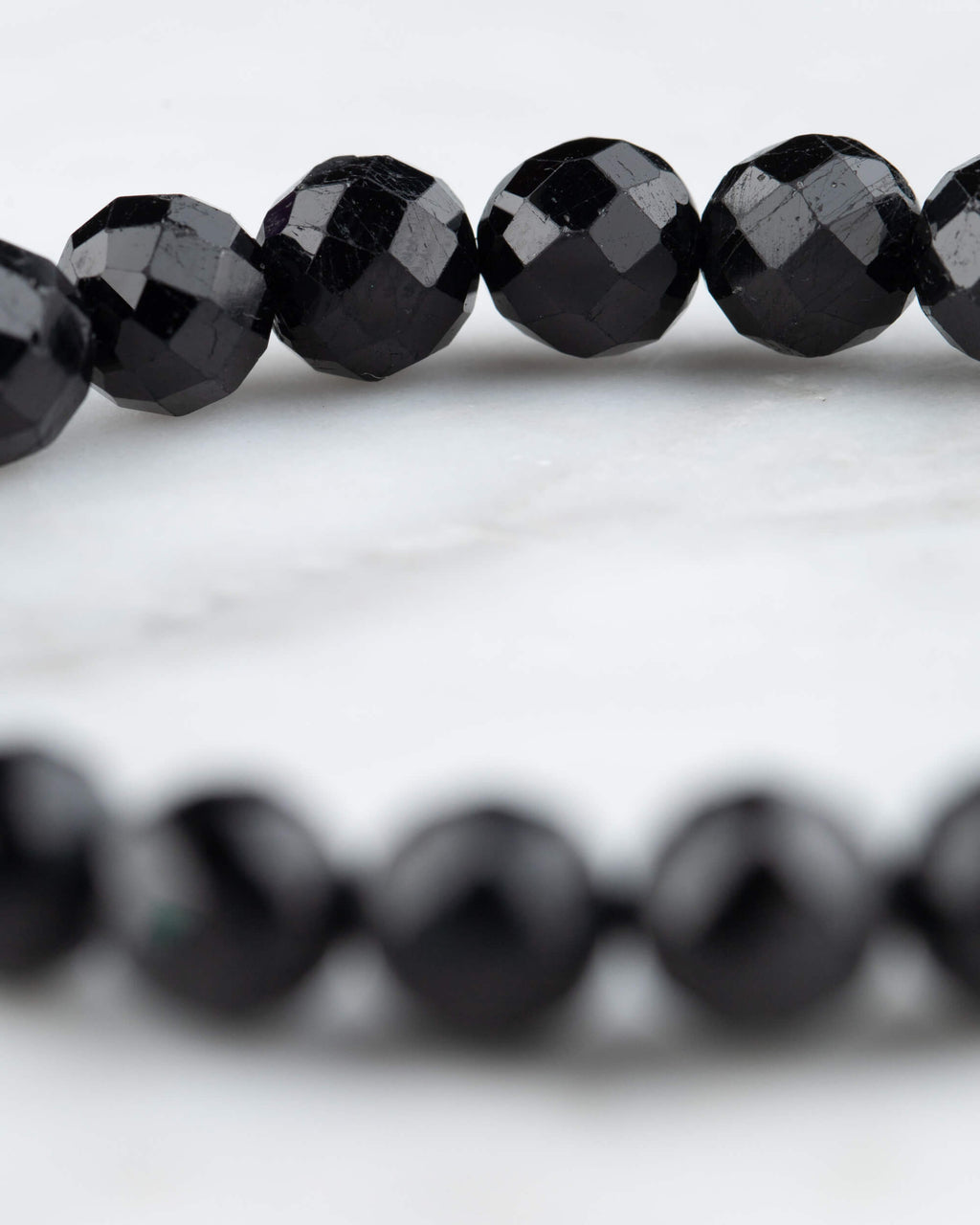 Cuentas facetadas de Turmalina Negra en primer plano, arco de la pulsera