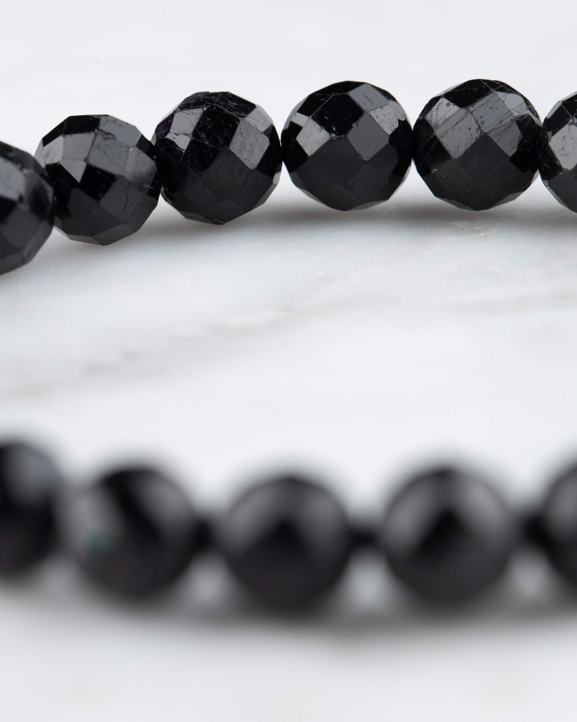 Cuentas facetadas de Turmalina Negra en primer plano, arco de la pulsera